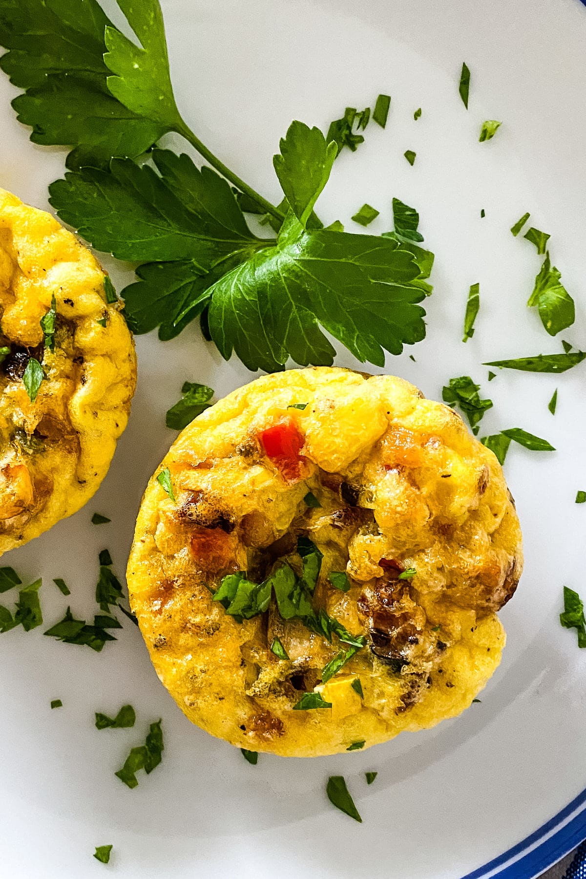 a muffin tin egg on a plate with parsley