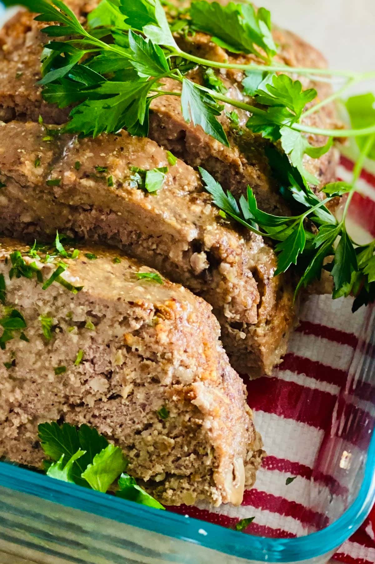 A sliced turkey meatloaf with mushrooms and fresh parsley