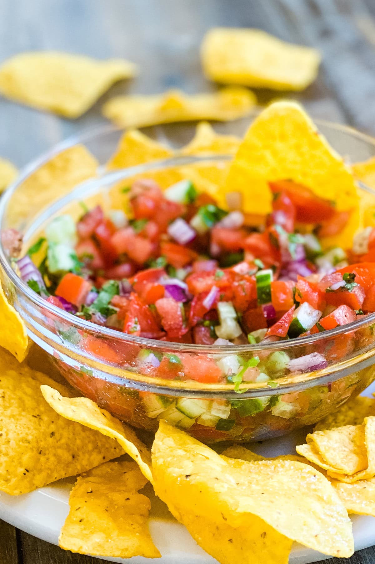 A bowl of Pico de Gallo recipe with tortilla chips around it.