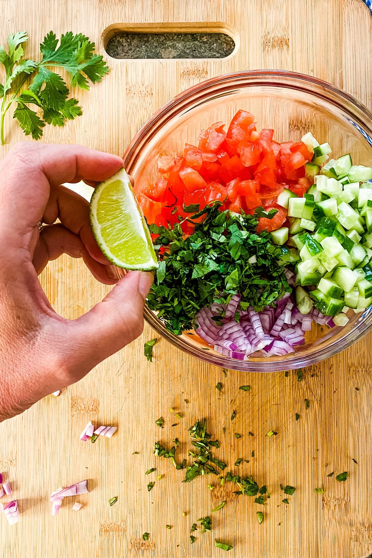 Adding lime to Pico de Gallo.