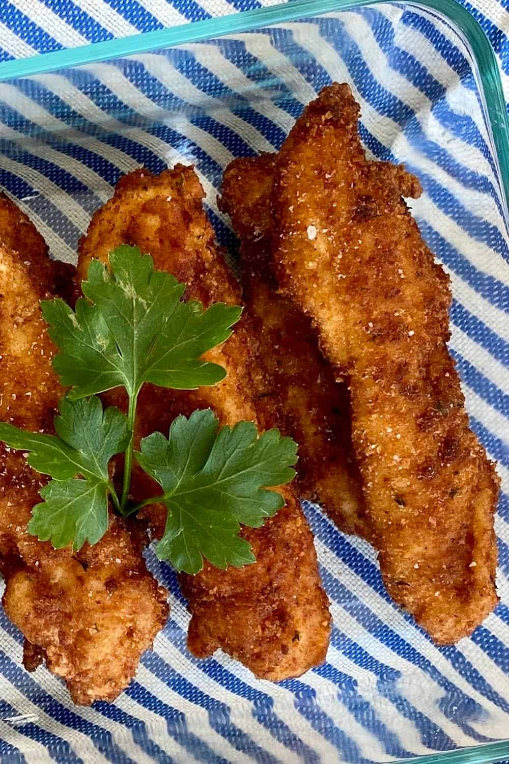 buttermilk fried chicken tenders on striped mat.