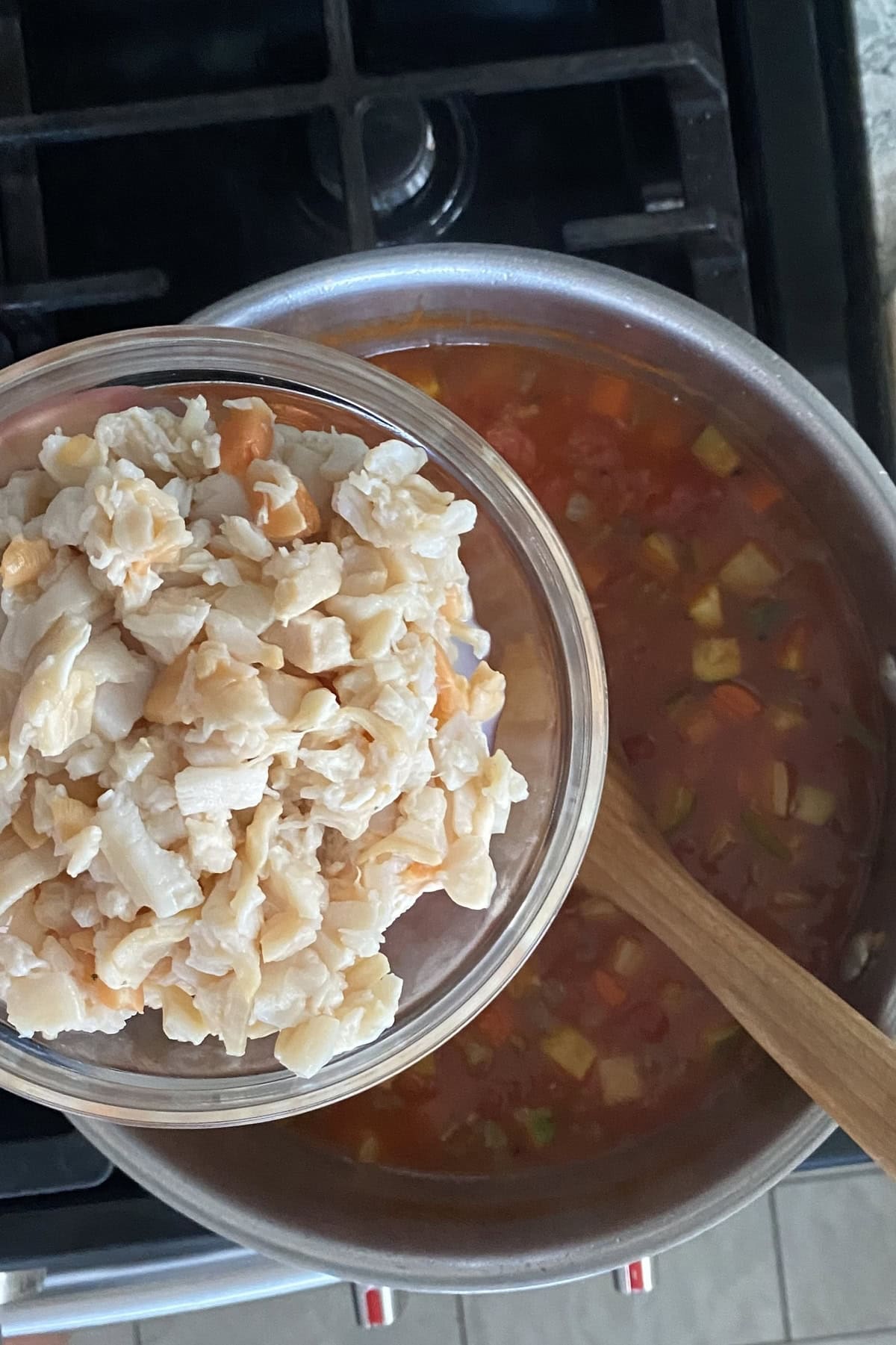 Adding clams to a chowder recipe.