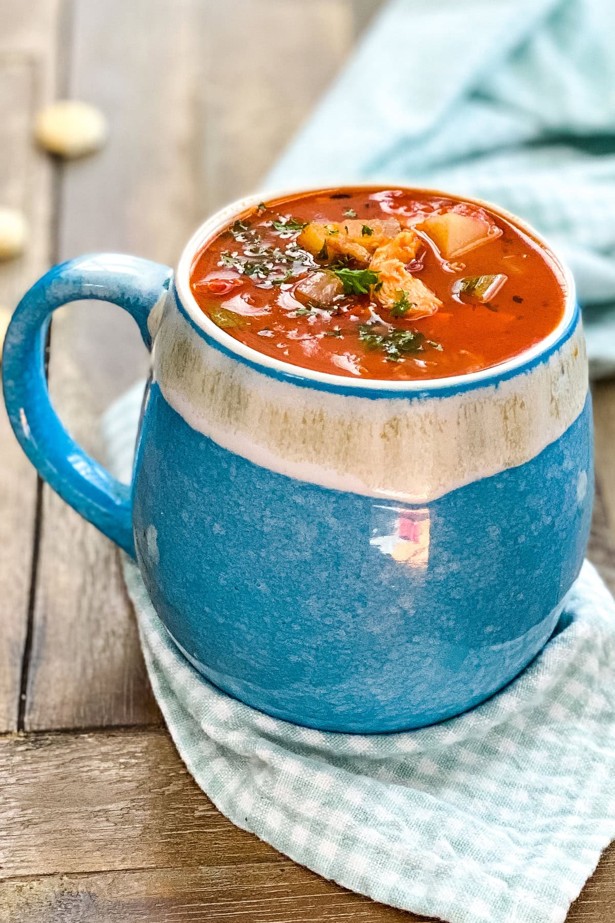 A mug of Grandma's Manhattan clam chowder placed on a table.