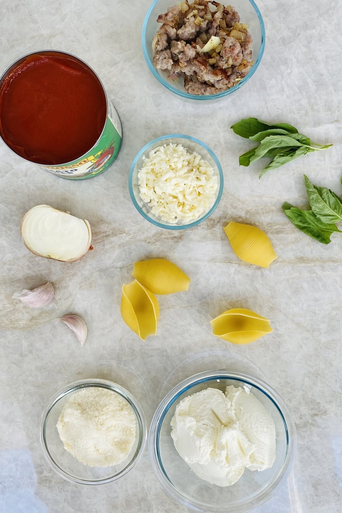 jumbo pasta shells, ricotta cheese, mozzarella cheese, parmesan cheese, garlic, onion, basil, crushed tomatoes, Italian sausage