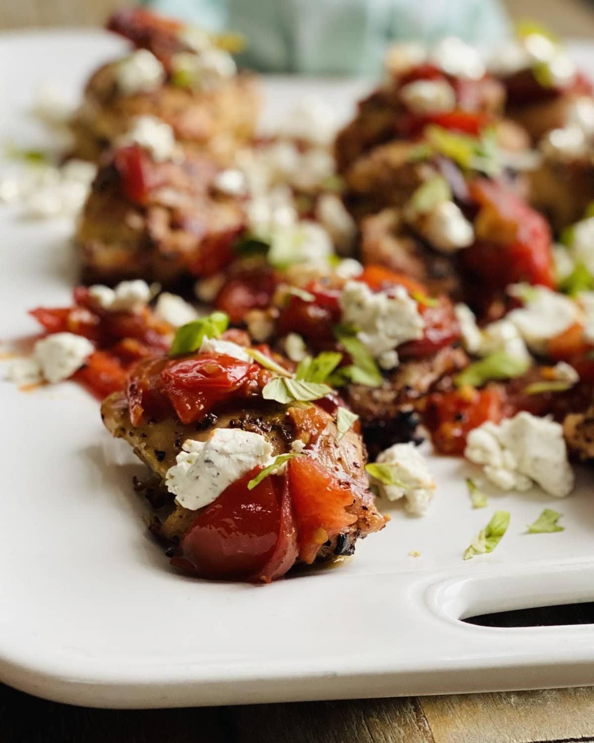 closeup of chicken thigh with bruschetta and goatcheese