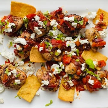 platter with grilled chicken thighs and sauteed tomatoes and goat cheese