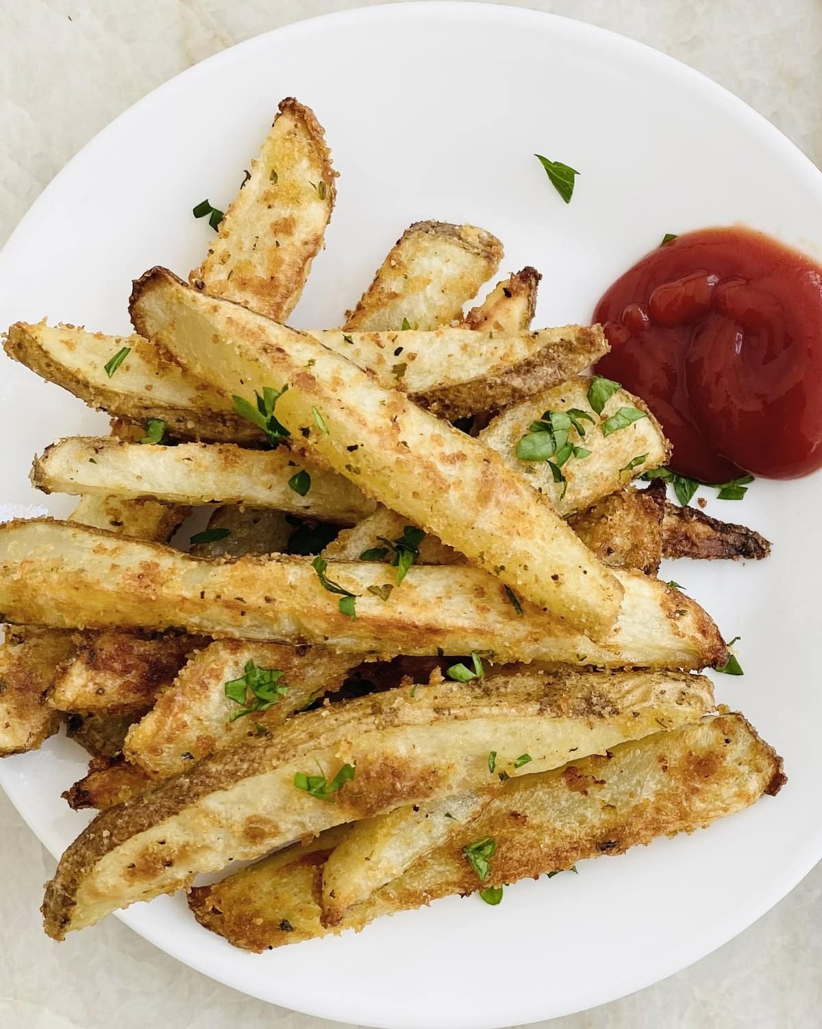 Plate of crispy oven fries with ketchup.