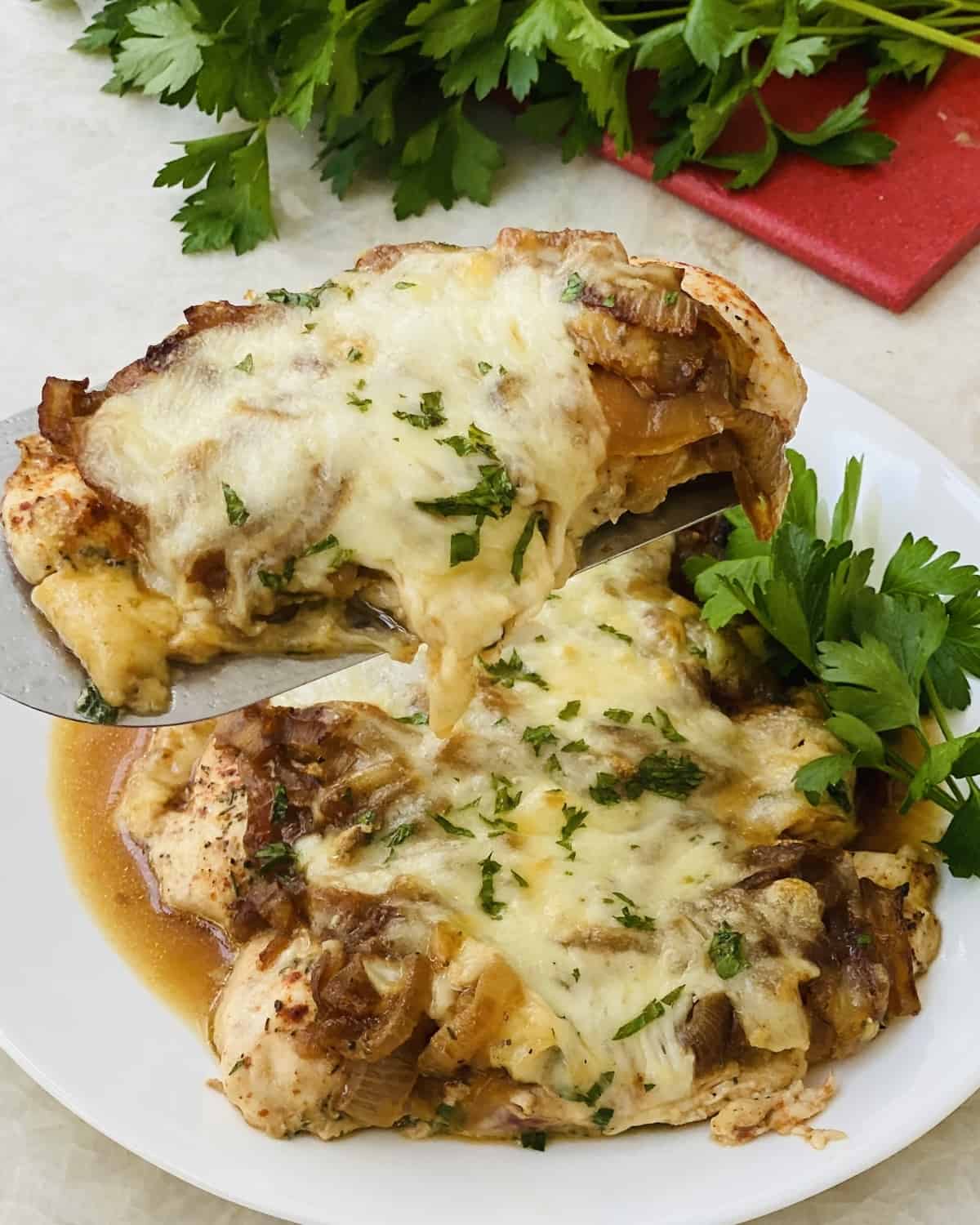 a spatula with a piece of French Onion Chicken on it