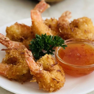 plate of crispy coconut shrimp with dipping sauce