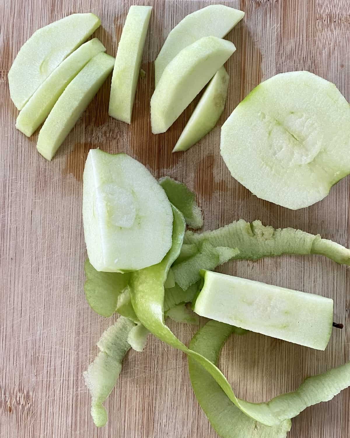 A sliced Granny Smith apple on a cutting board.