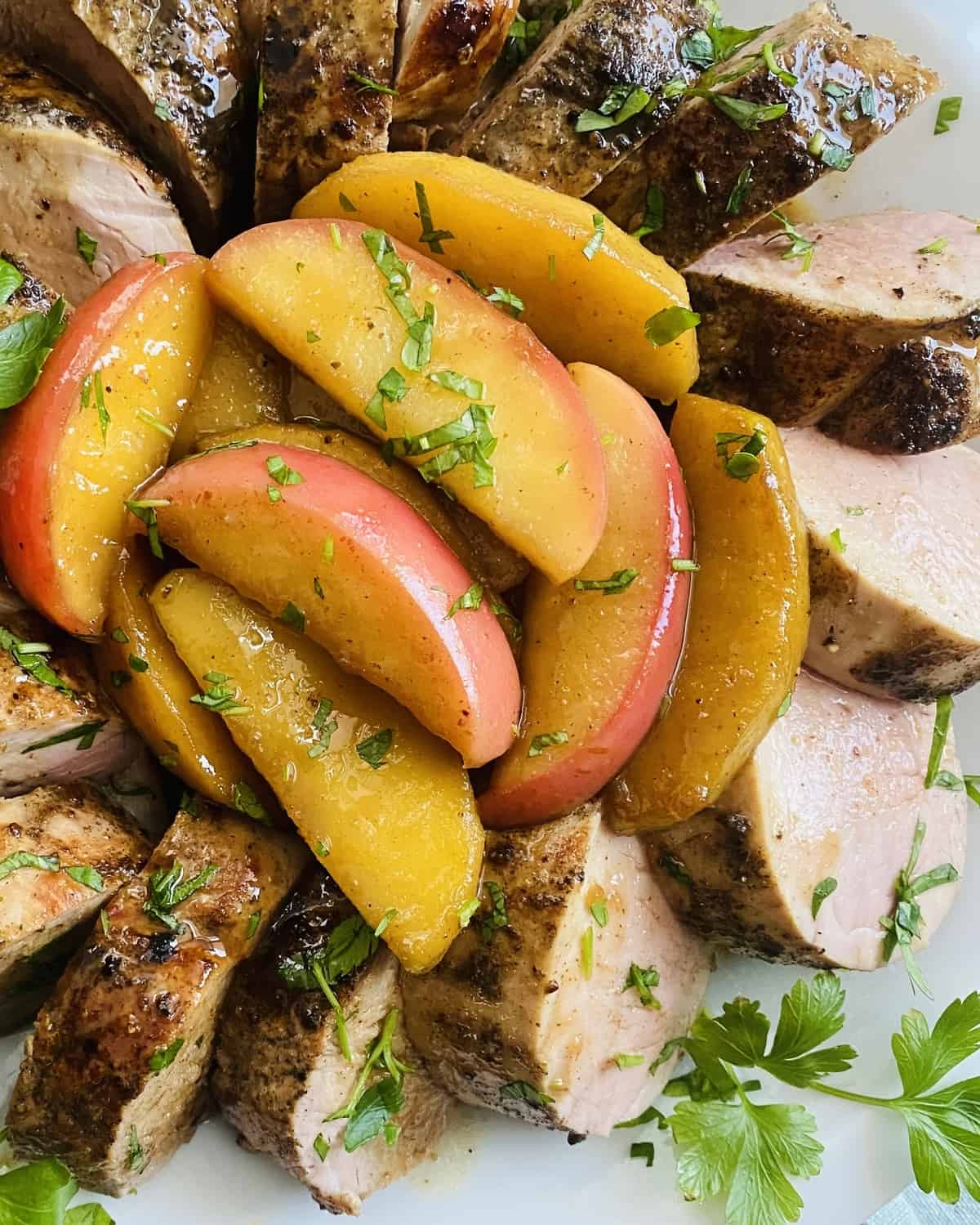Sautéed apples with maple glaze and pork tenderloin on a plate.