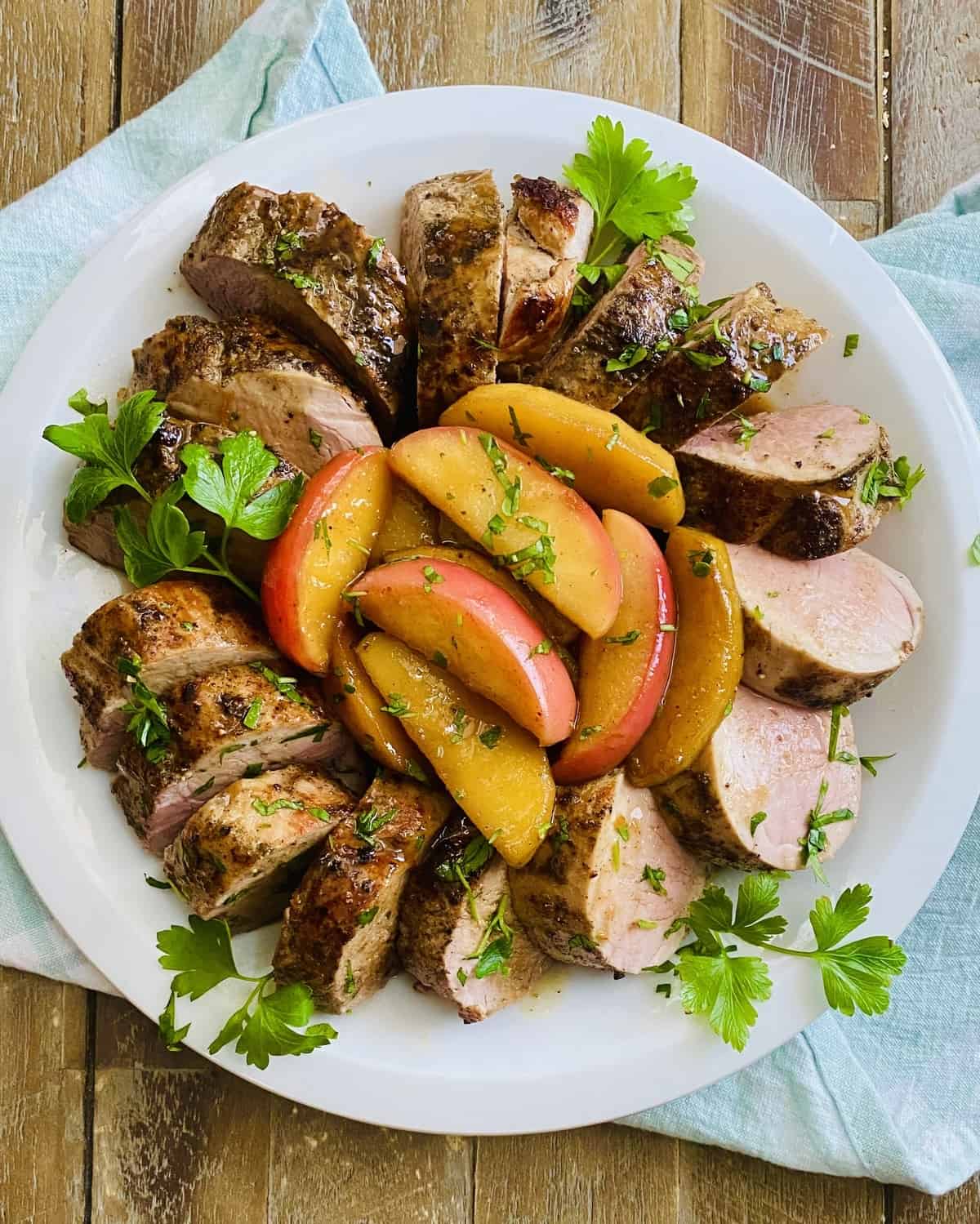 A platter of roasted pork with apples.