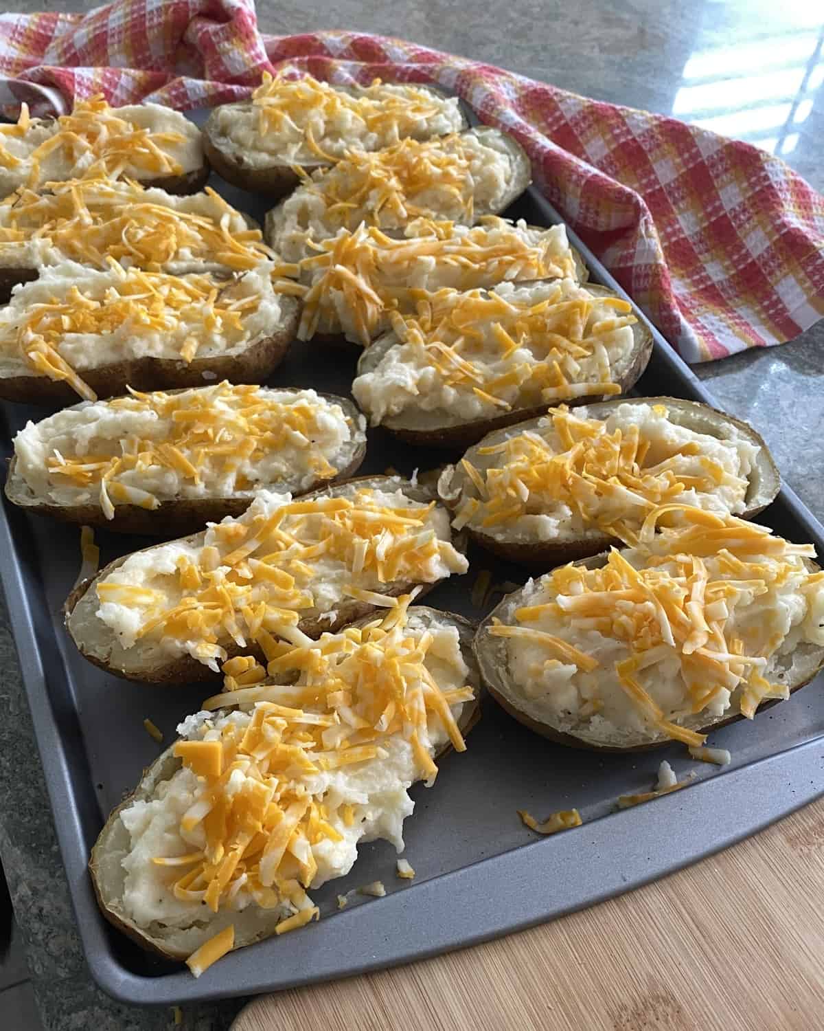 pan of cheddar stuffed potatoes ready to be baked
