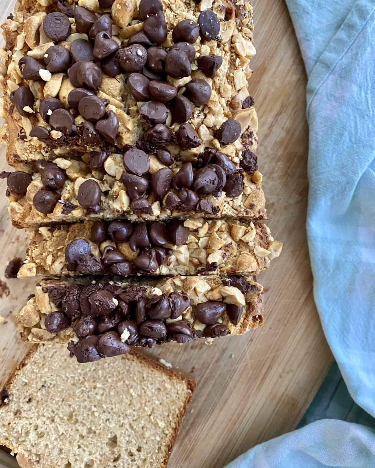 sliced loaf of peanut butter bread topped with peanuts and chocolate chips