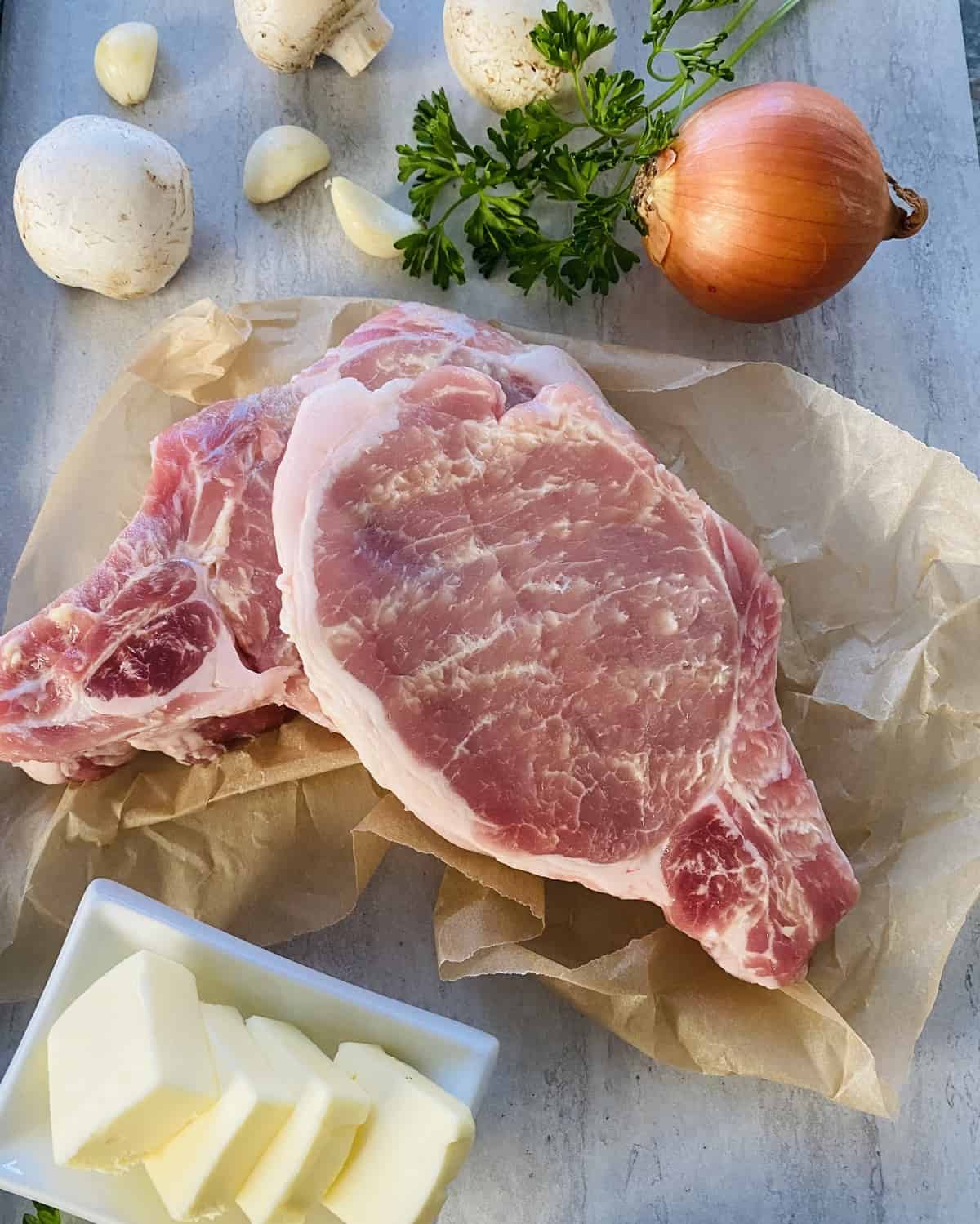 2 bone-in Berkshire pork chops on a counter.