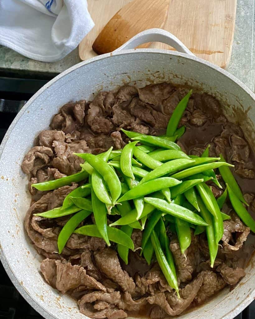 adding sugar snap peas to stir fry