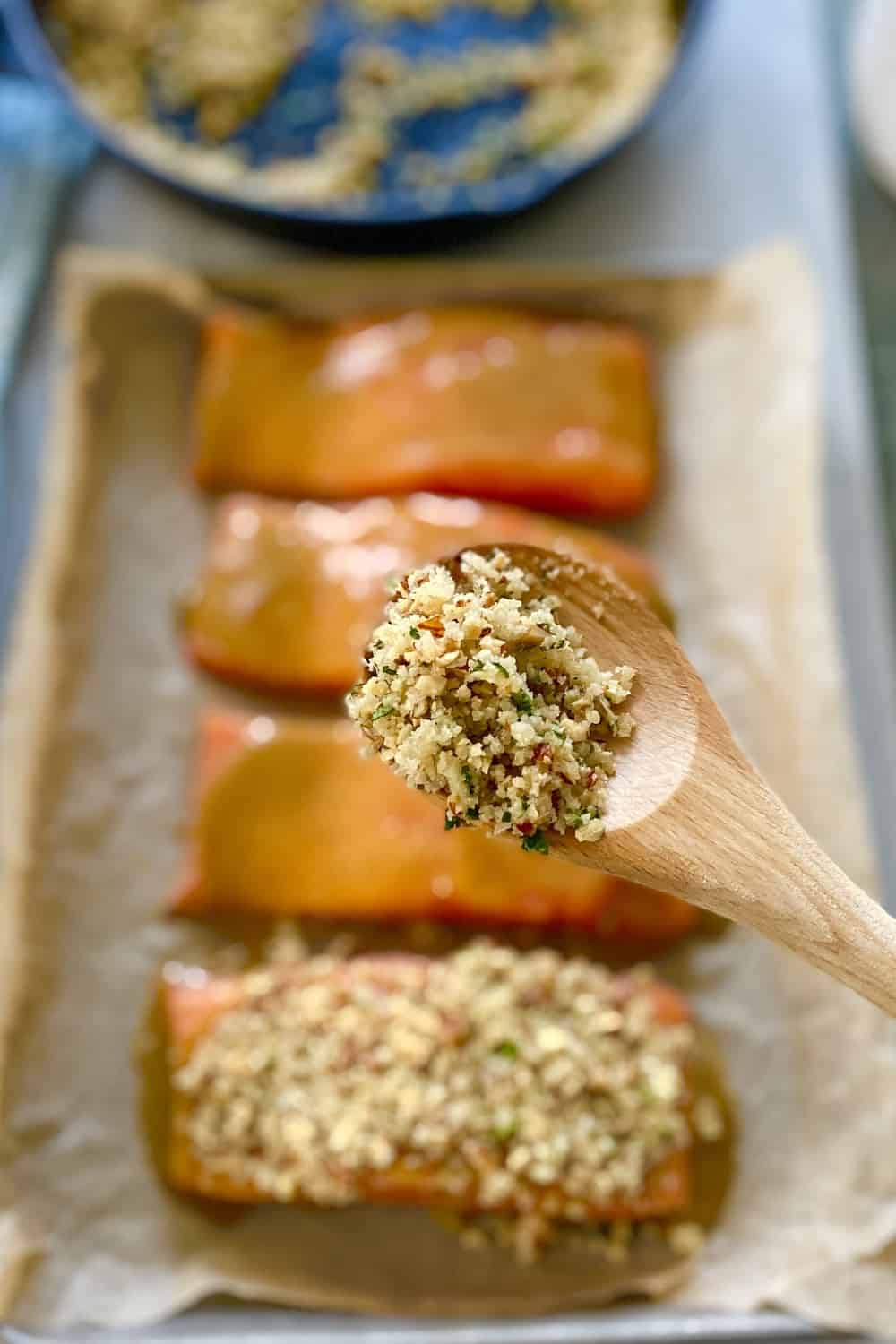 A spoon with pecan topping for salmon.