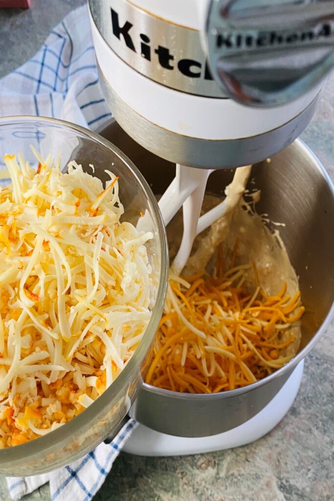adding shredded cheese to mixer