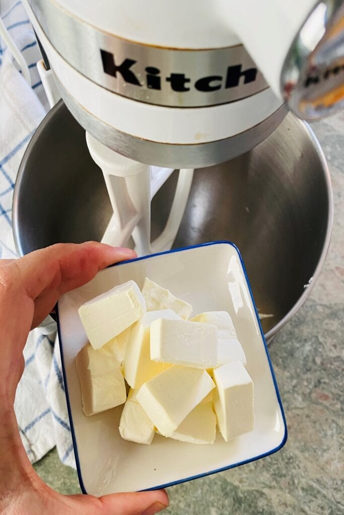 adding cream cheese to mixer