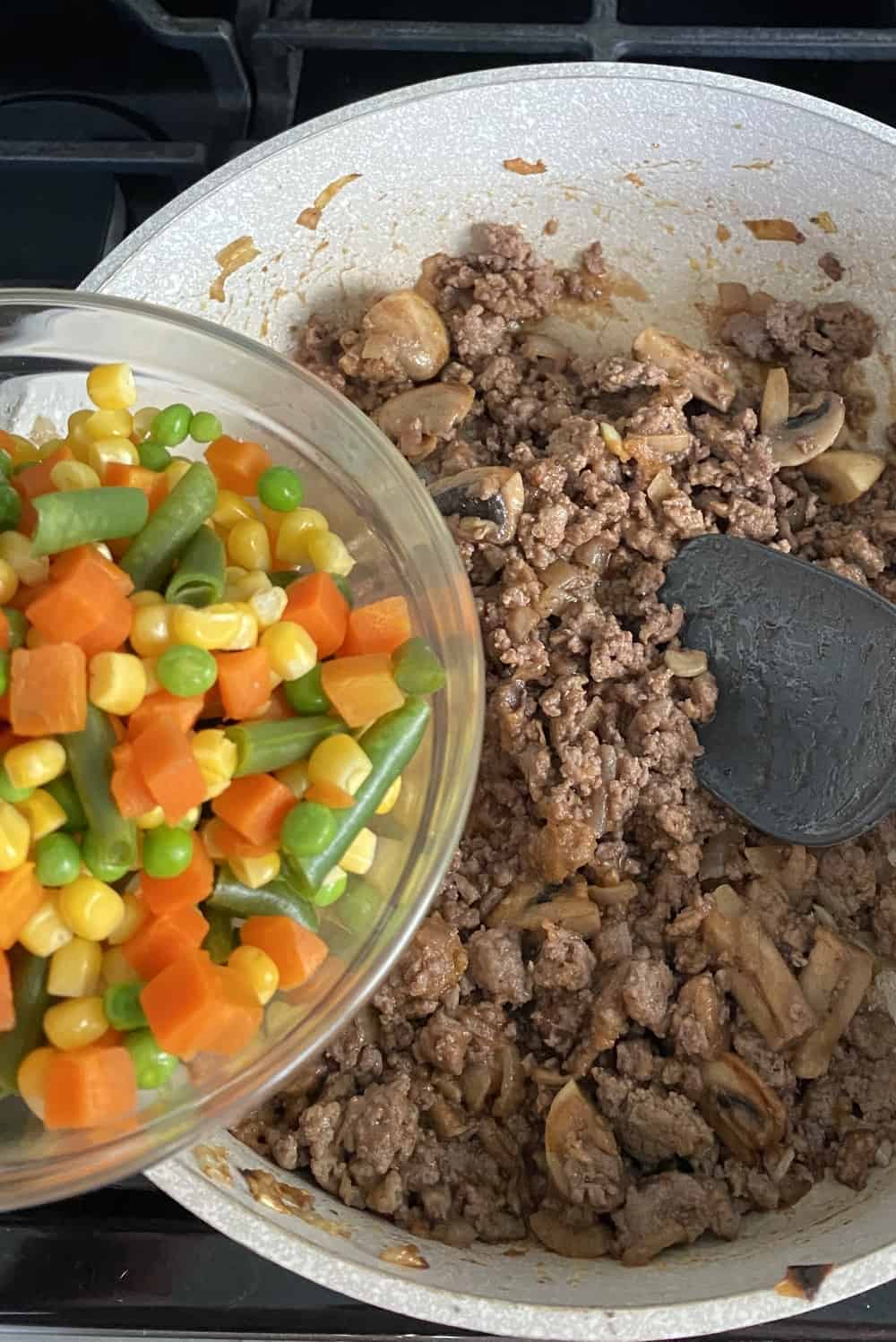 Added frozen mixed vegetables to browned ground turkey.