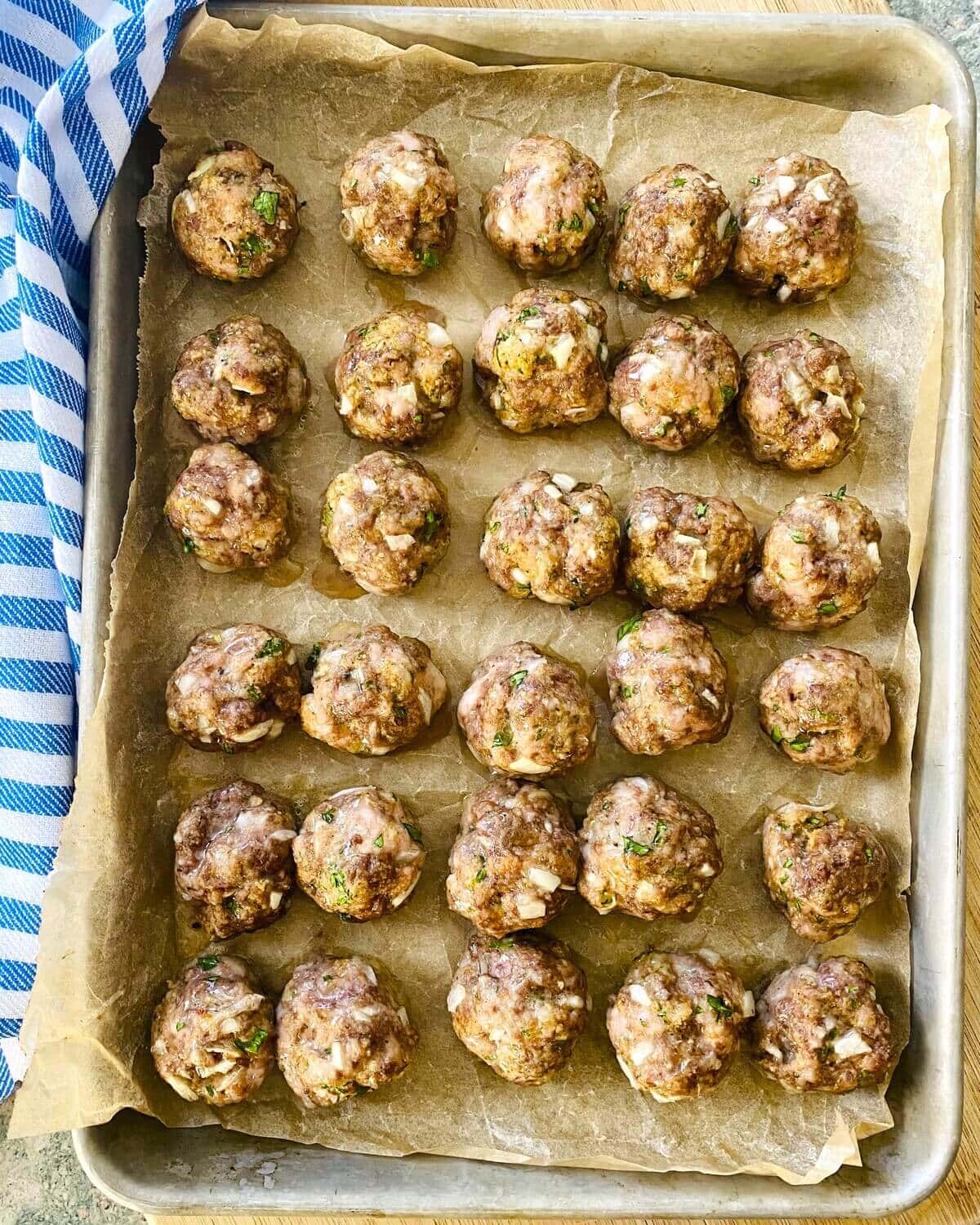 Baked meatballs on a baking sheet.