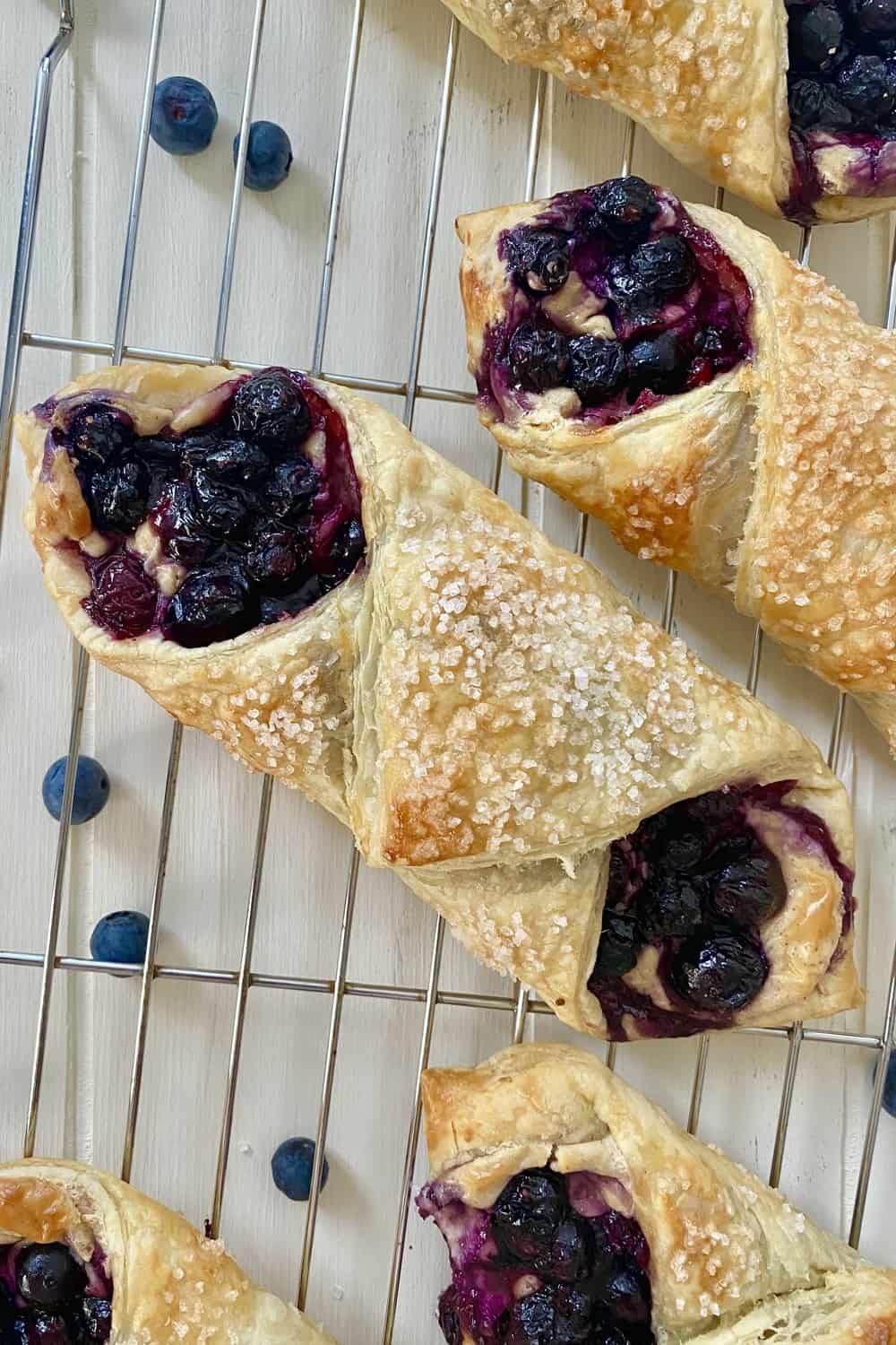 Blueberry danish with sugar on top and on a cooling rack.