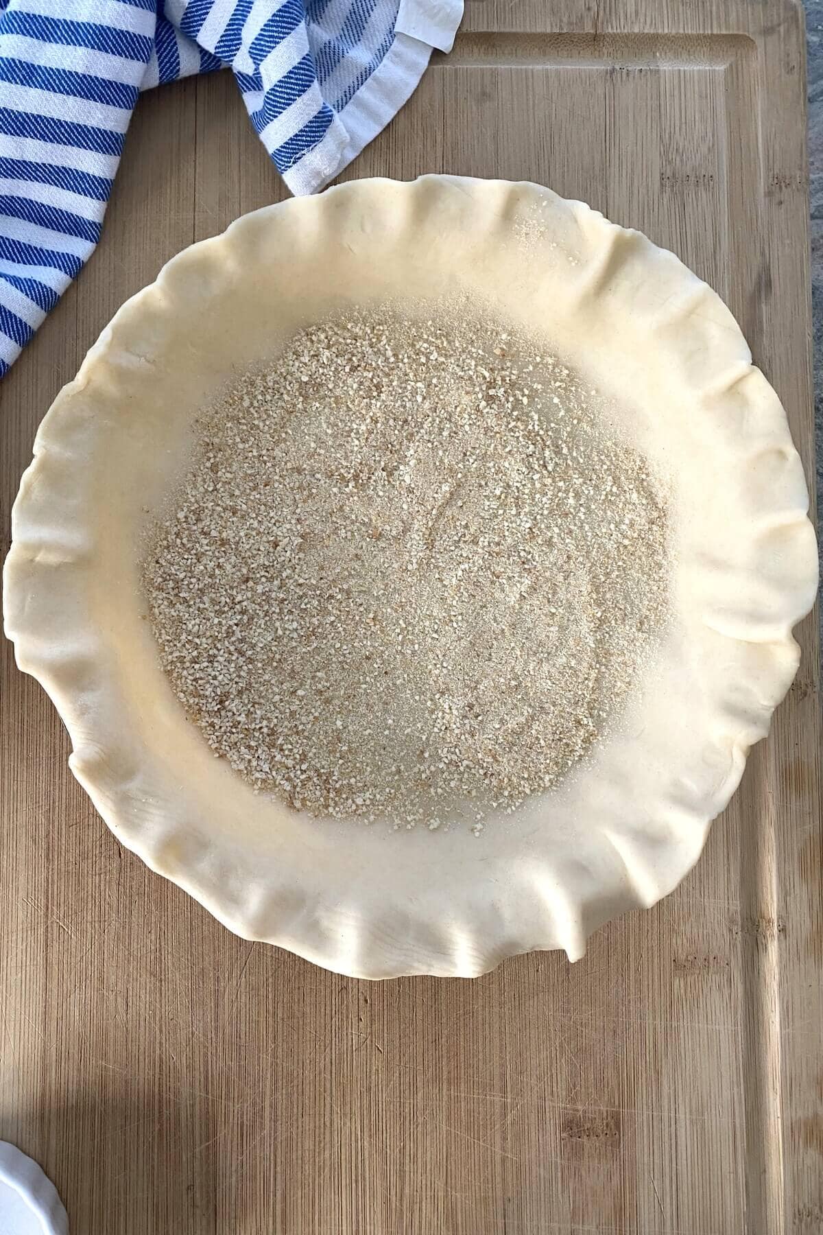 An unbaked pie crust with dry breadcrumbs in it.