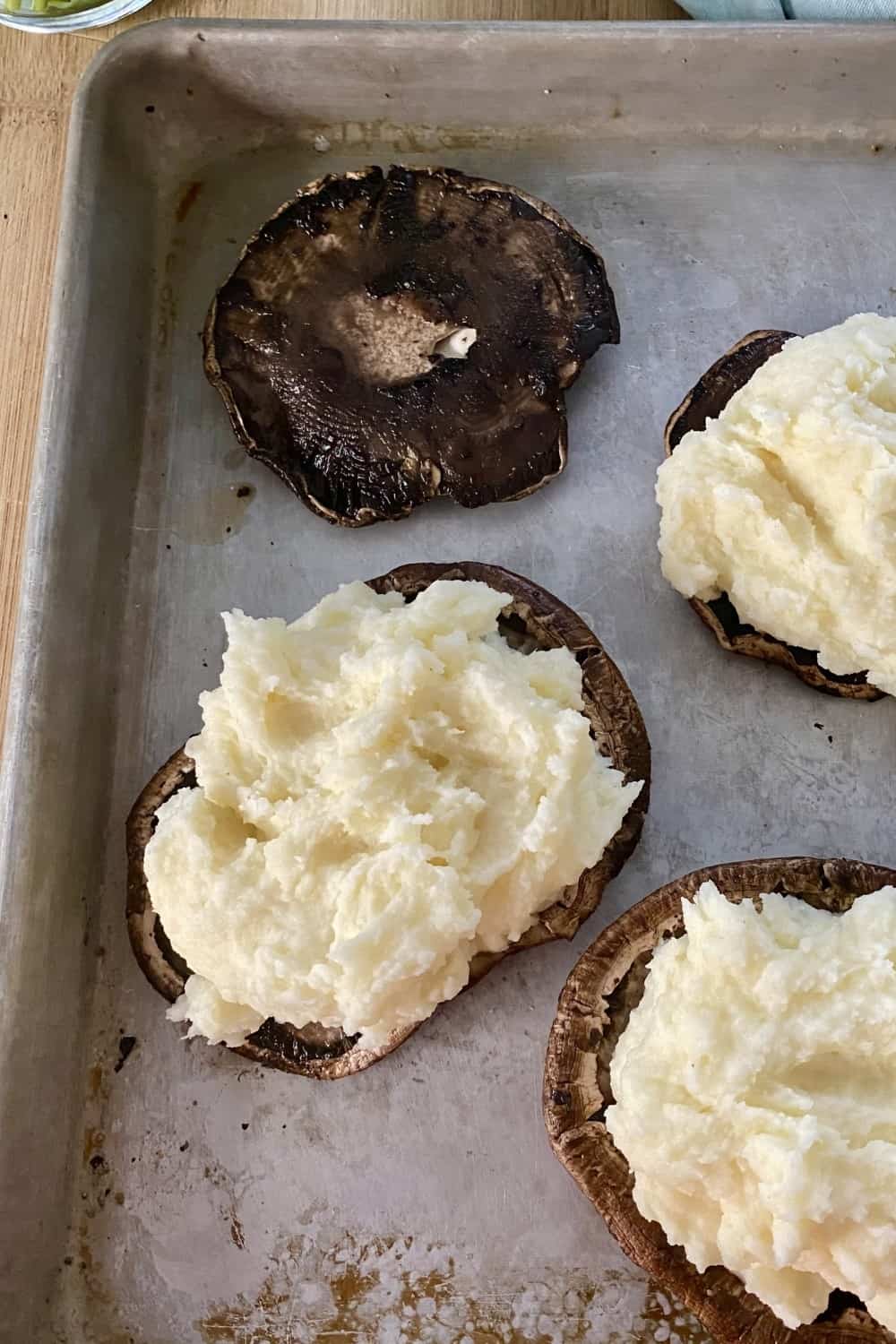 Stuffing roasted mushroom caps with mashed potatoes.