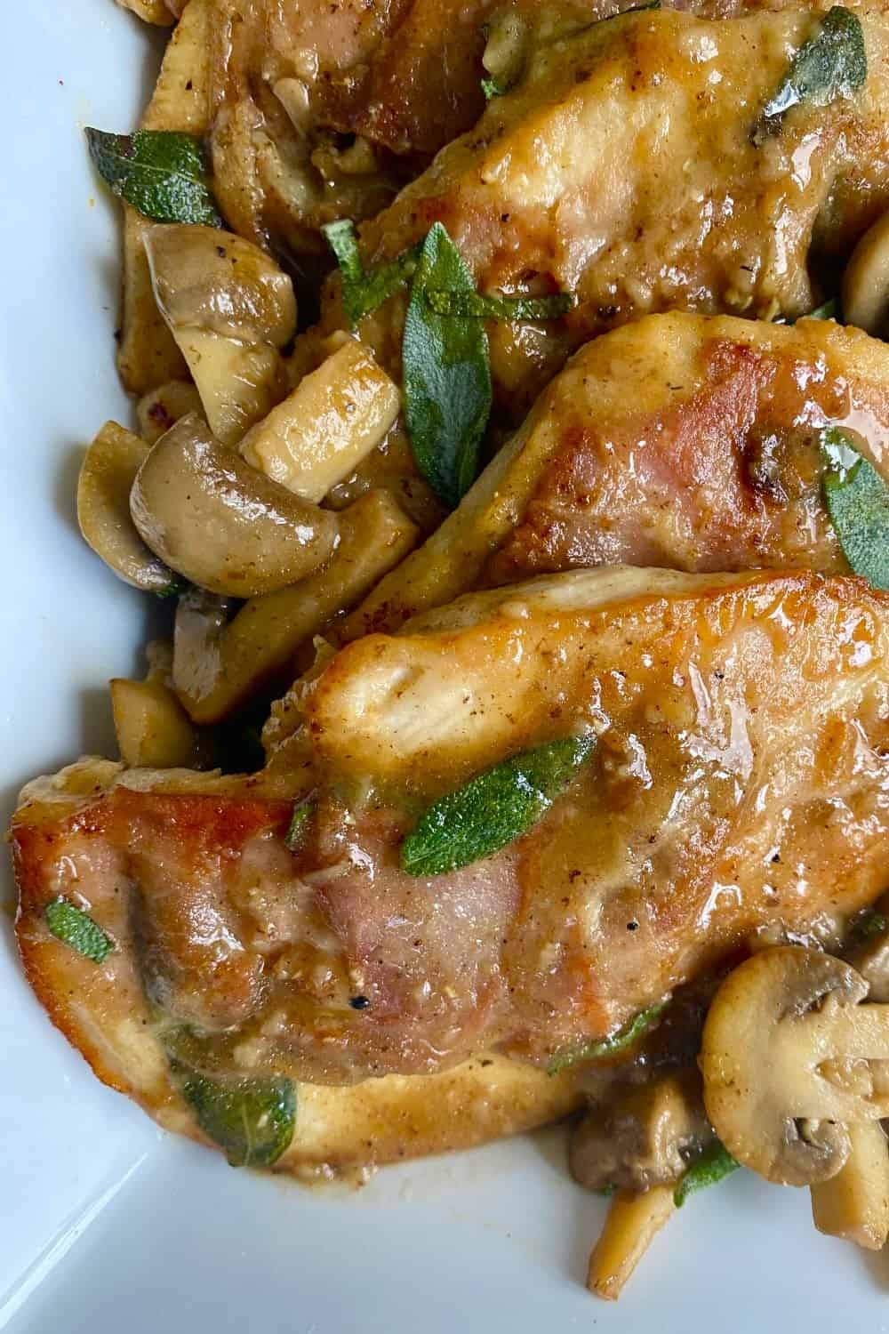 Chicken with prosciutto and a mushroom sauce in a serving dish.