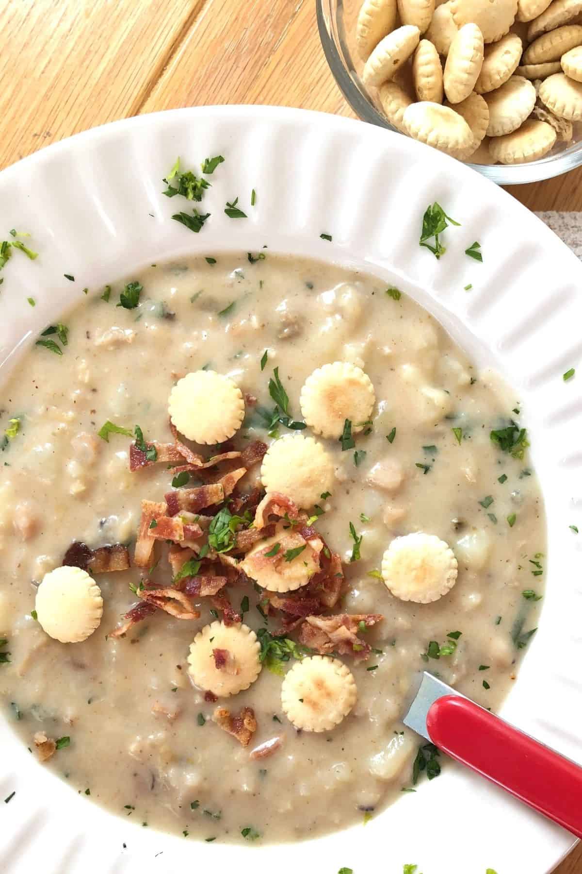 large bowl of New England clam chowder with oyster crackers.