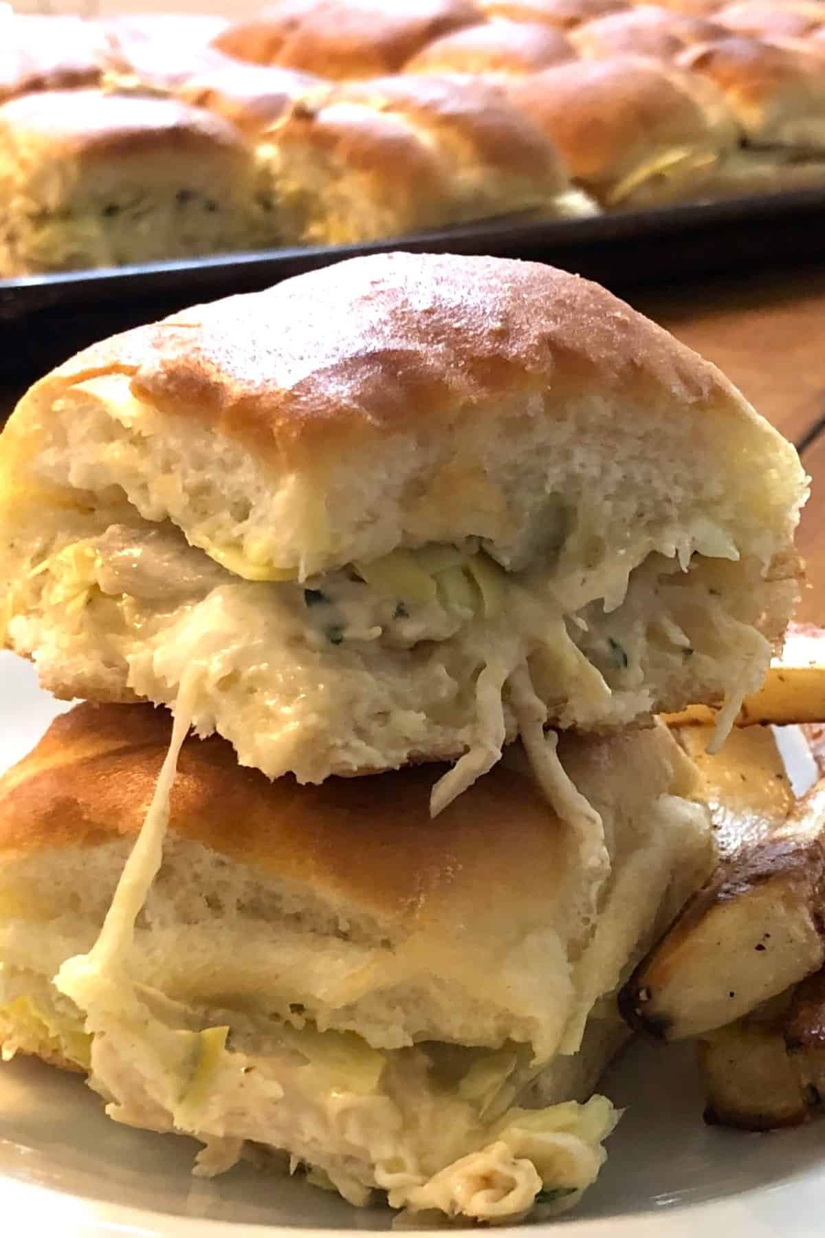 two turkey sliders stacked on top of each other with French fries.