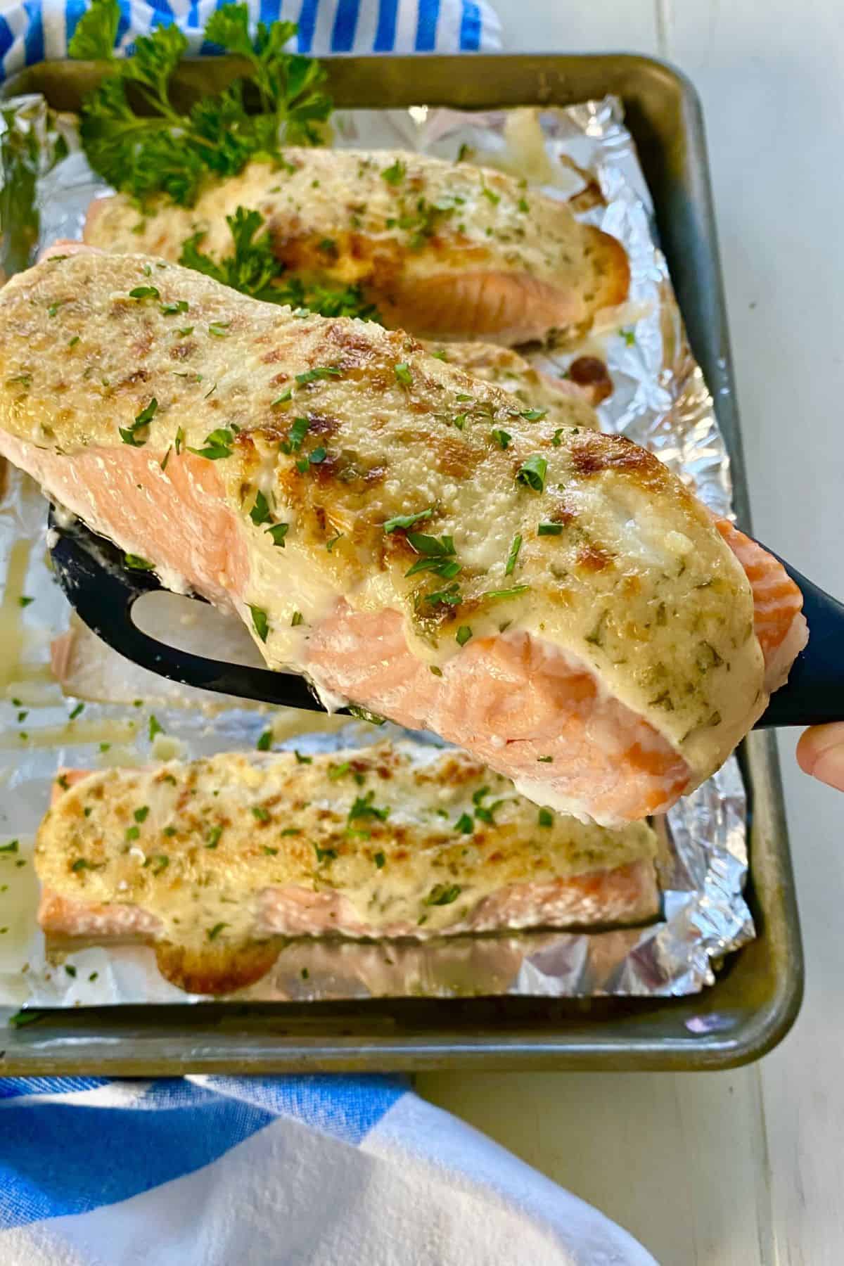 salmon with Caesar topping on a spatula.