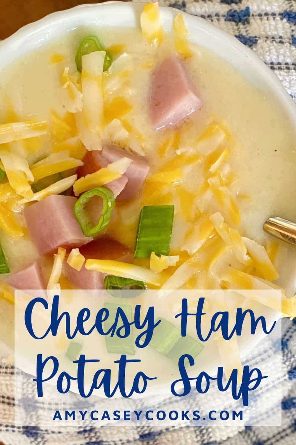 big bowl of cheesy ham and potato soup with blue and white napkin.