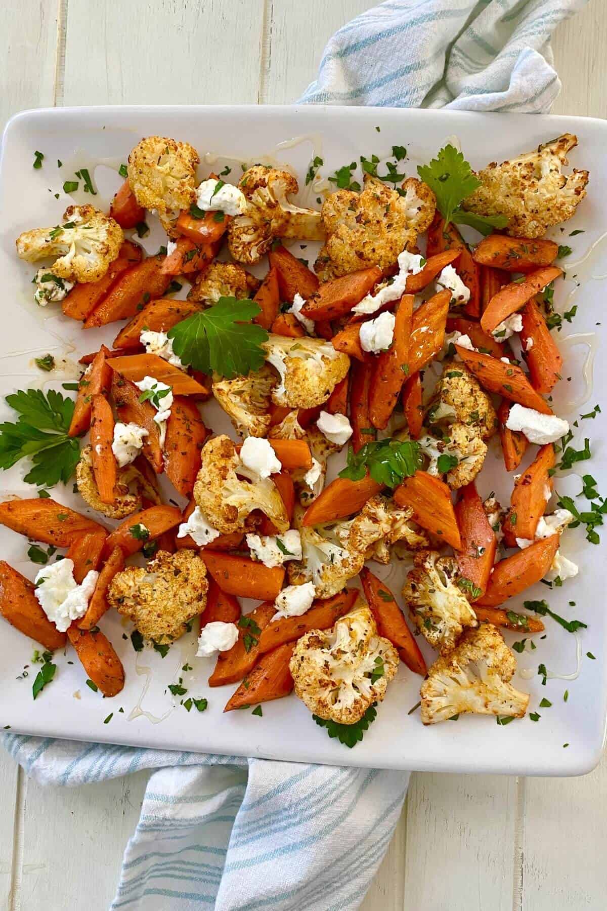 roasted carrots and cauliflower with goat cheese on a plate.