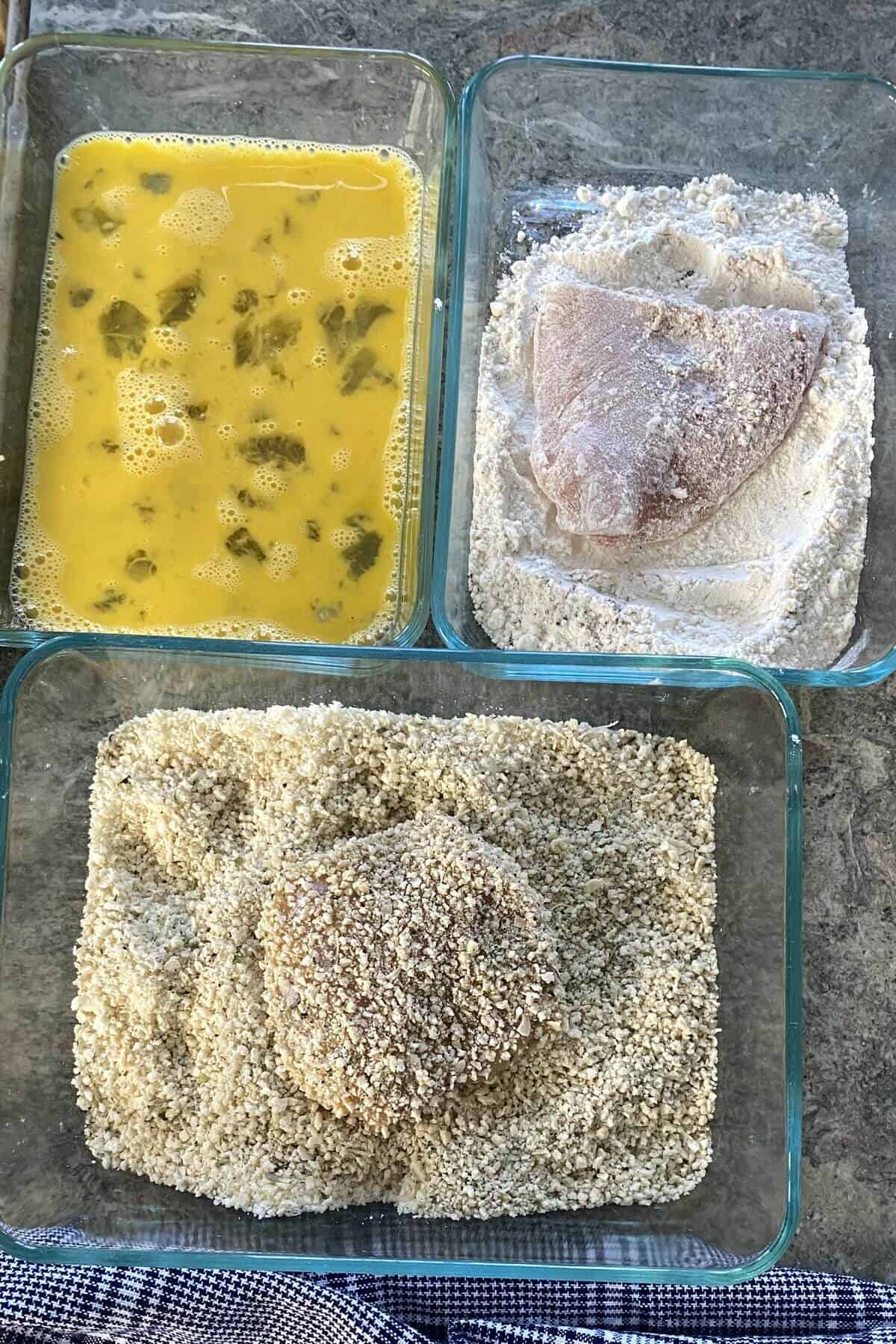 Breading chicken in egg, flour and bread crumbs.