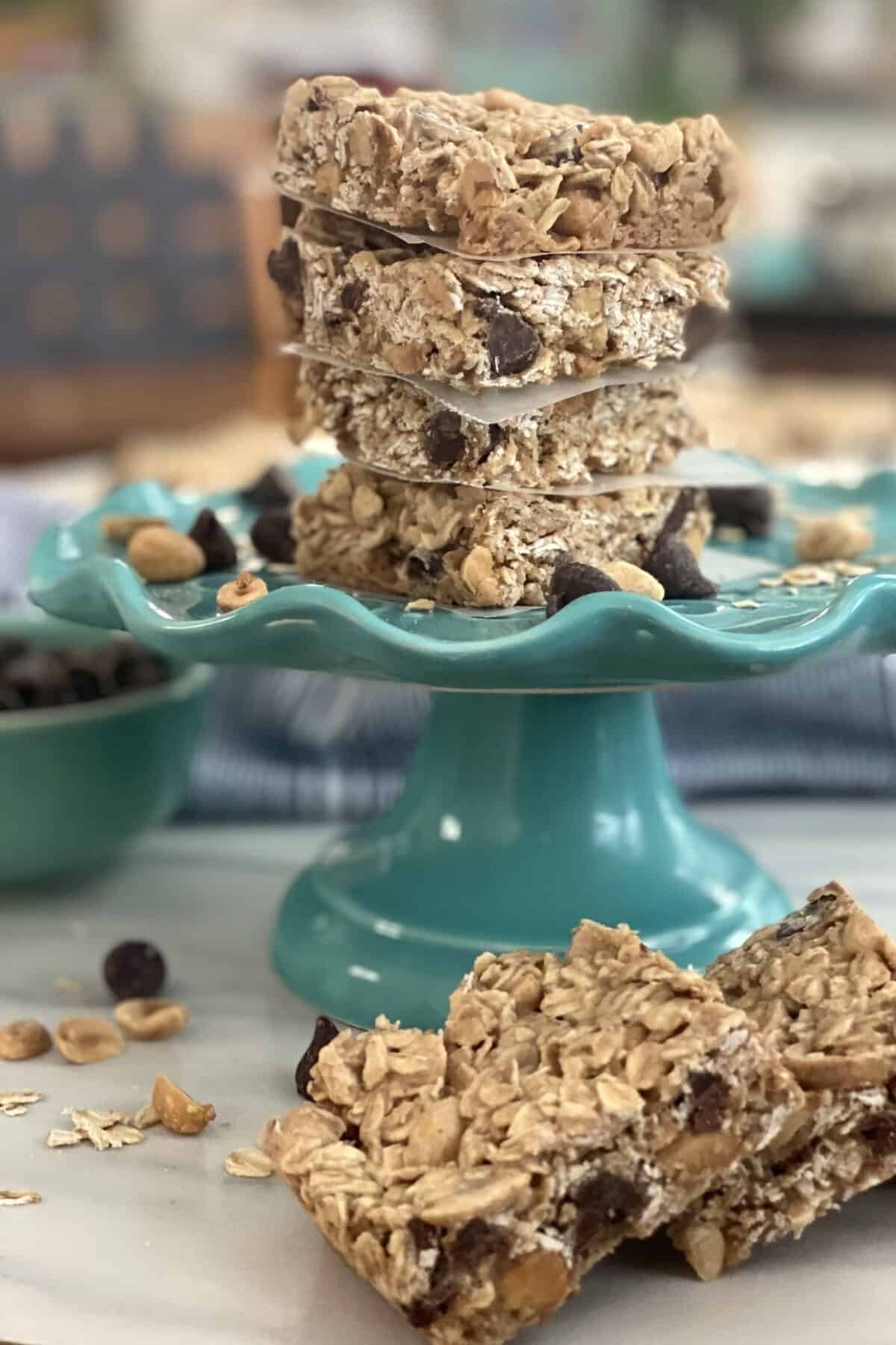 4 peanut butter oat bars stacked on top of a plate.