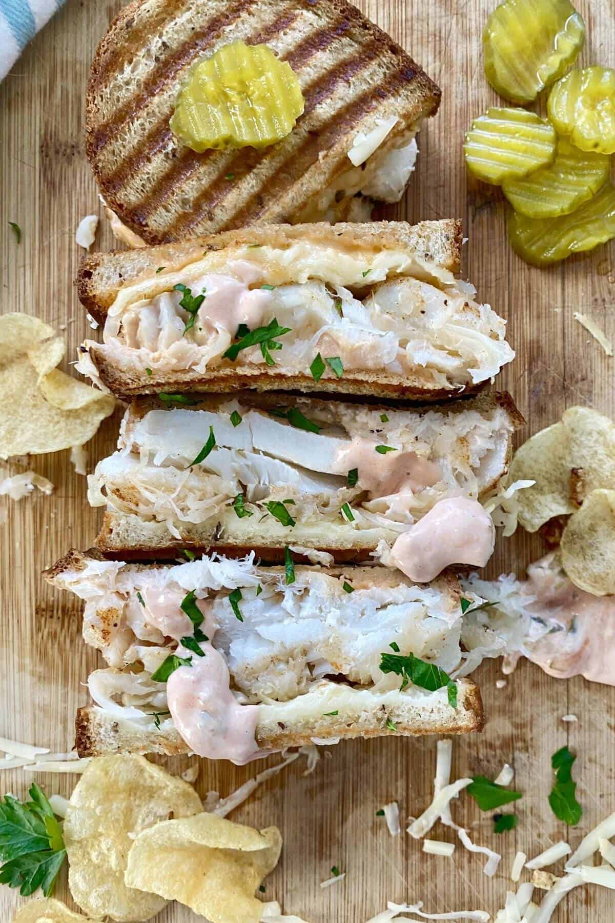3 halves of a fish reuben sandwich.
