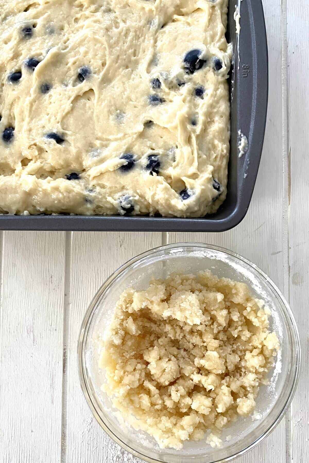 Adding crumb topping to cake in pan.