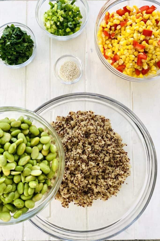 adding edamame to cooked quinoa.