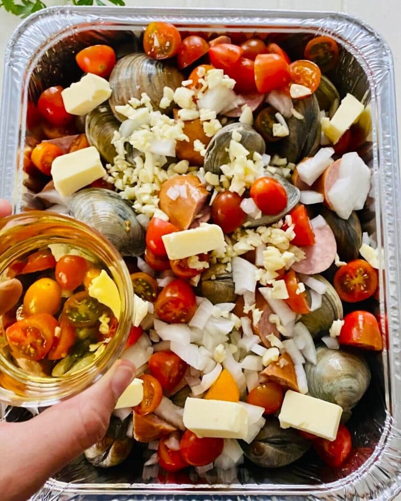 adding wine to shellfish and kielbasa.