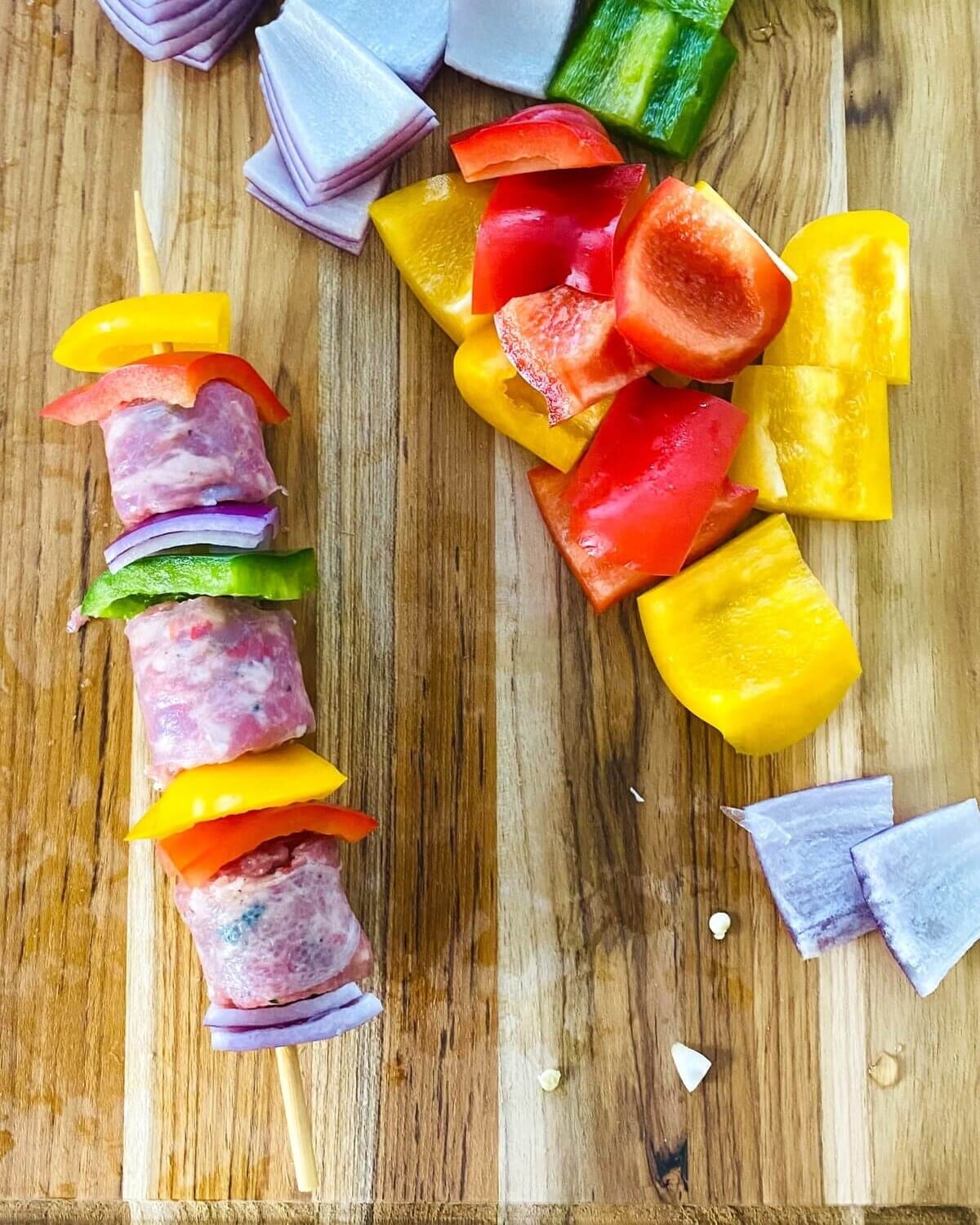 Sausage kabobs on cutting board.