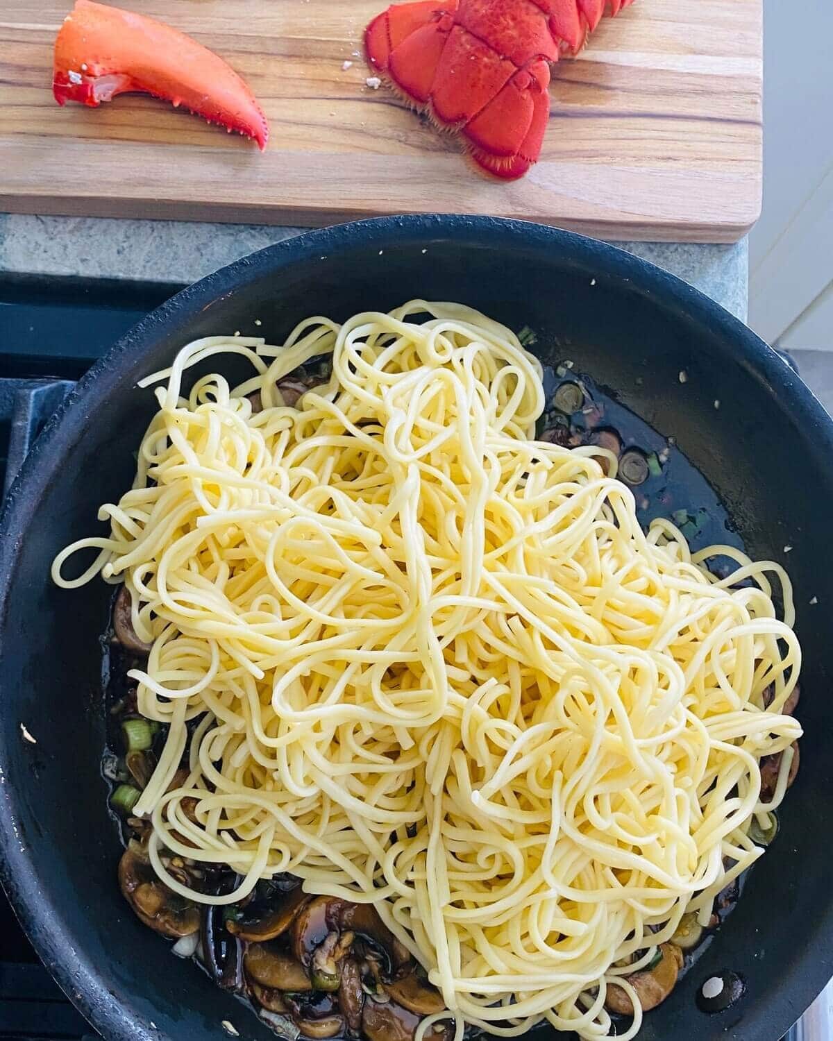 Add noodles to lobster stir fry.