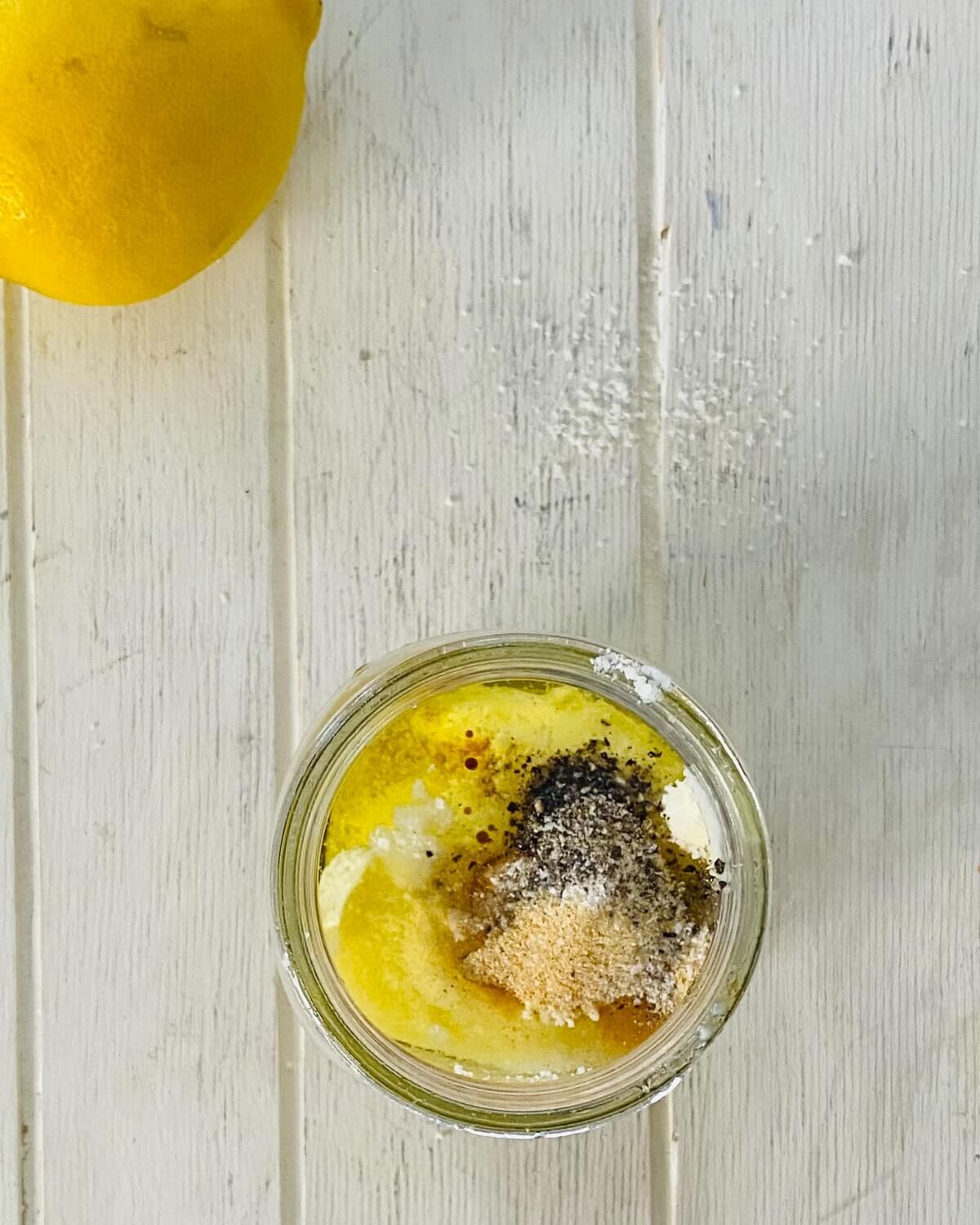 ingredients for Caesar salad dressing without anchovies in a mason jar.