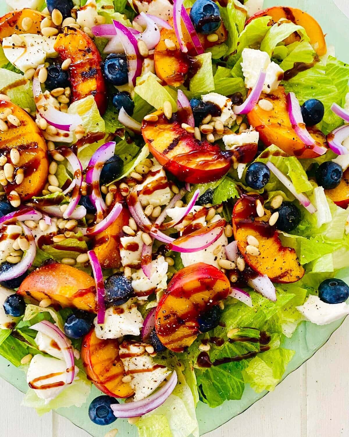 Grilled peach salad with mozzarella on a platter.
