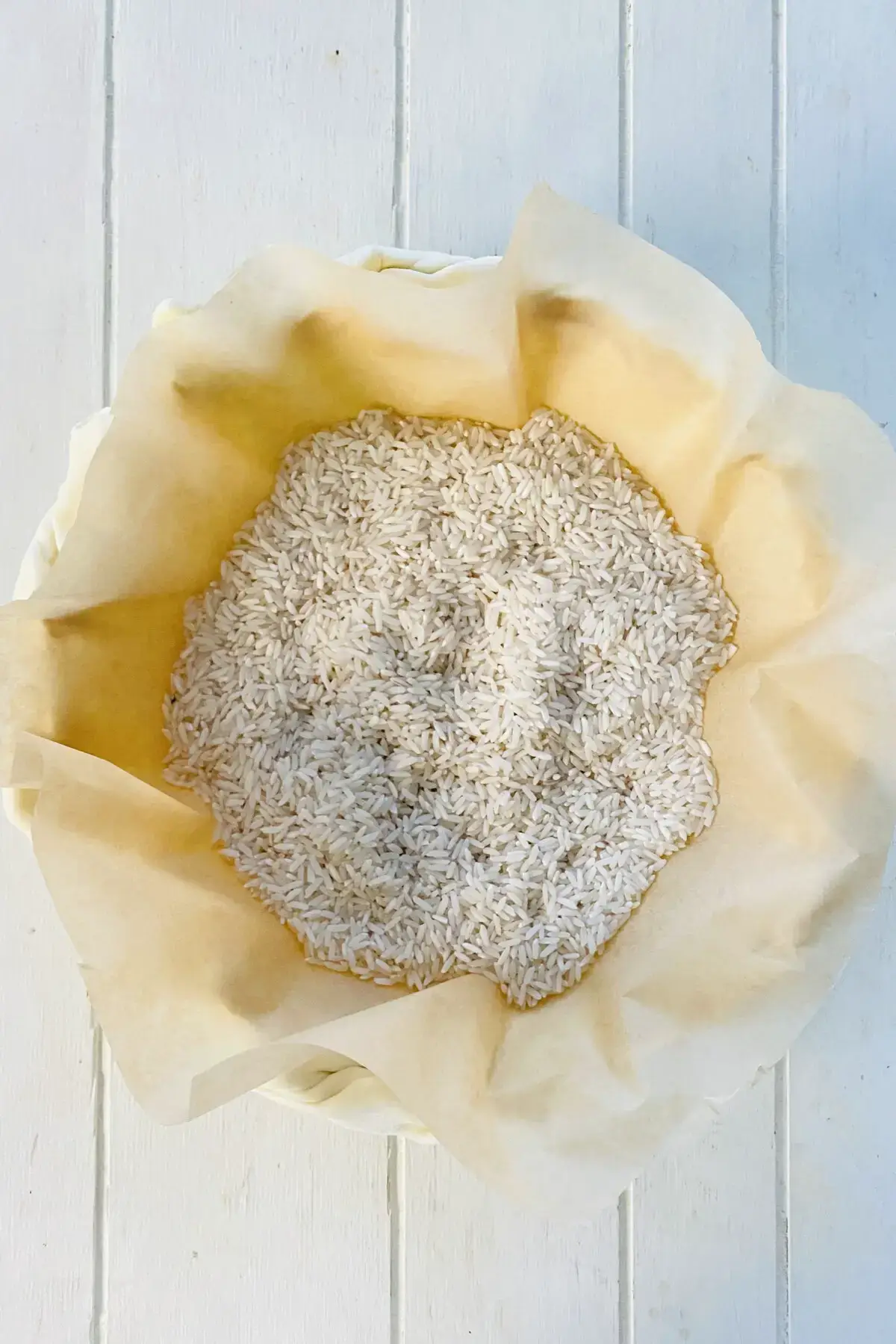 lining crust with parchment paper and uncooked rice to parbake.