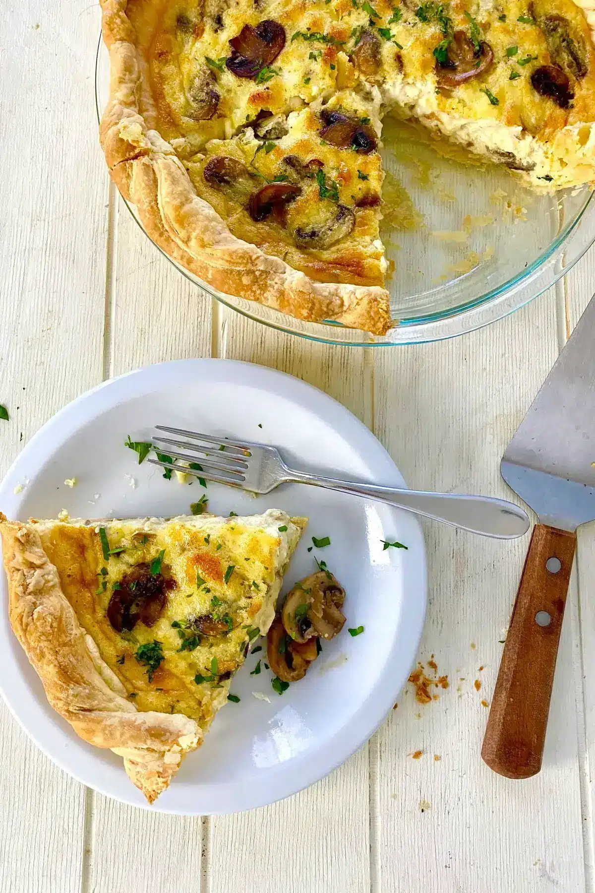 slice of mushroom quiche and the remainder of the quiche.