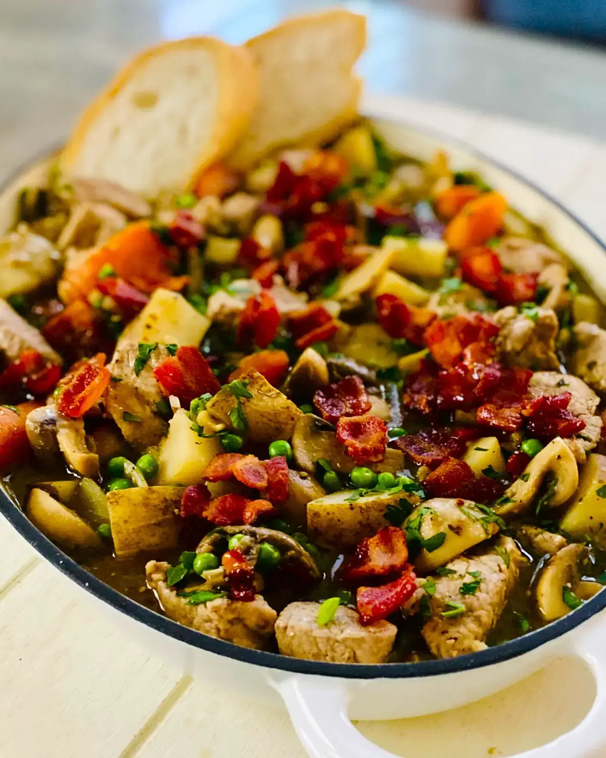 Pork tenderloin stew topped with bacon and parsley.