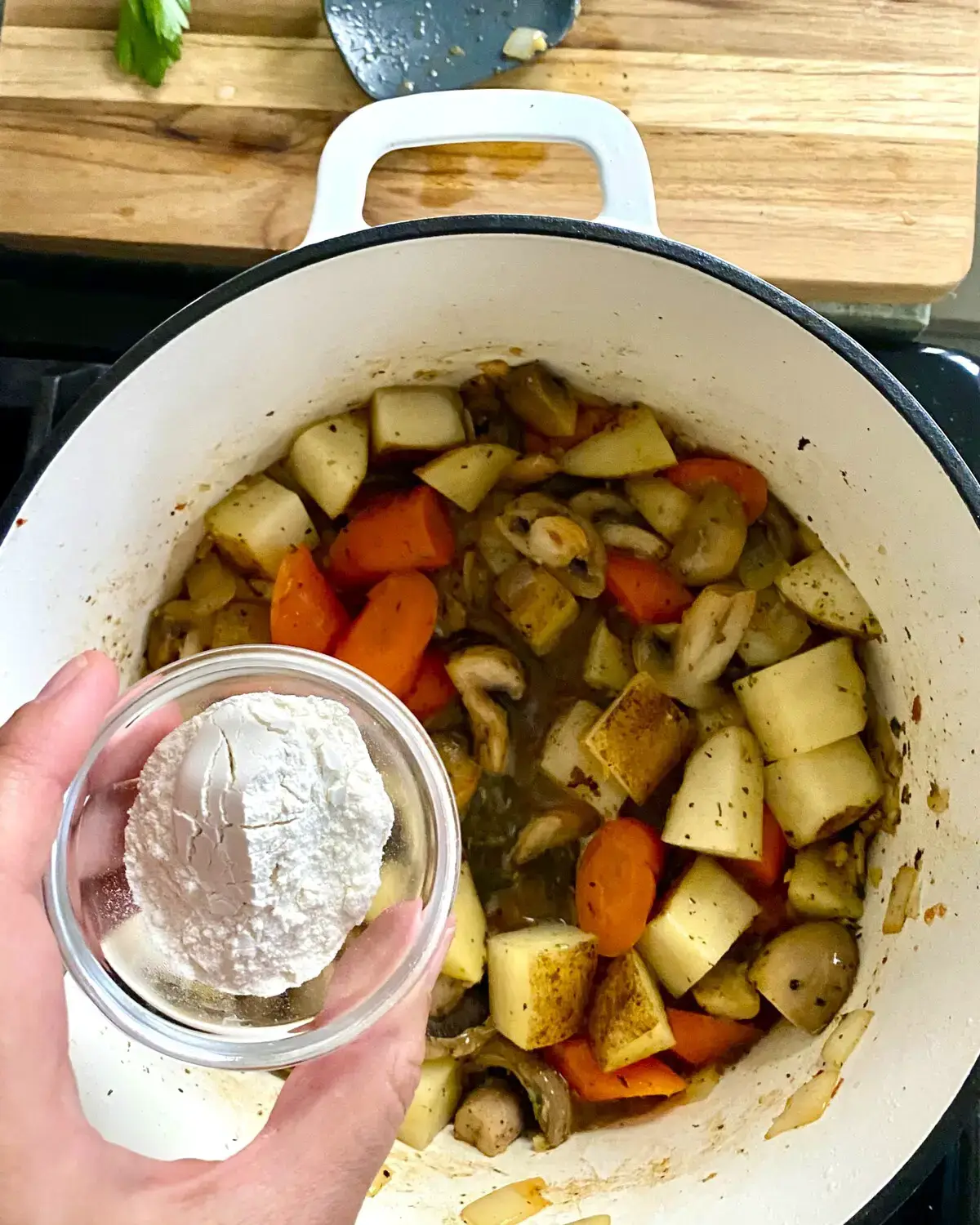 Adding flour to pork stew.