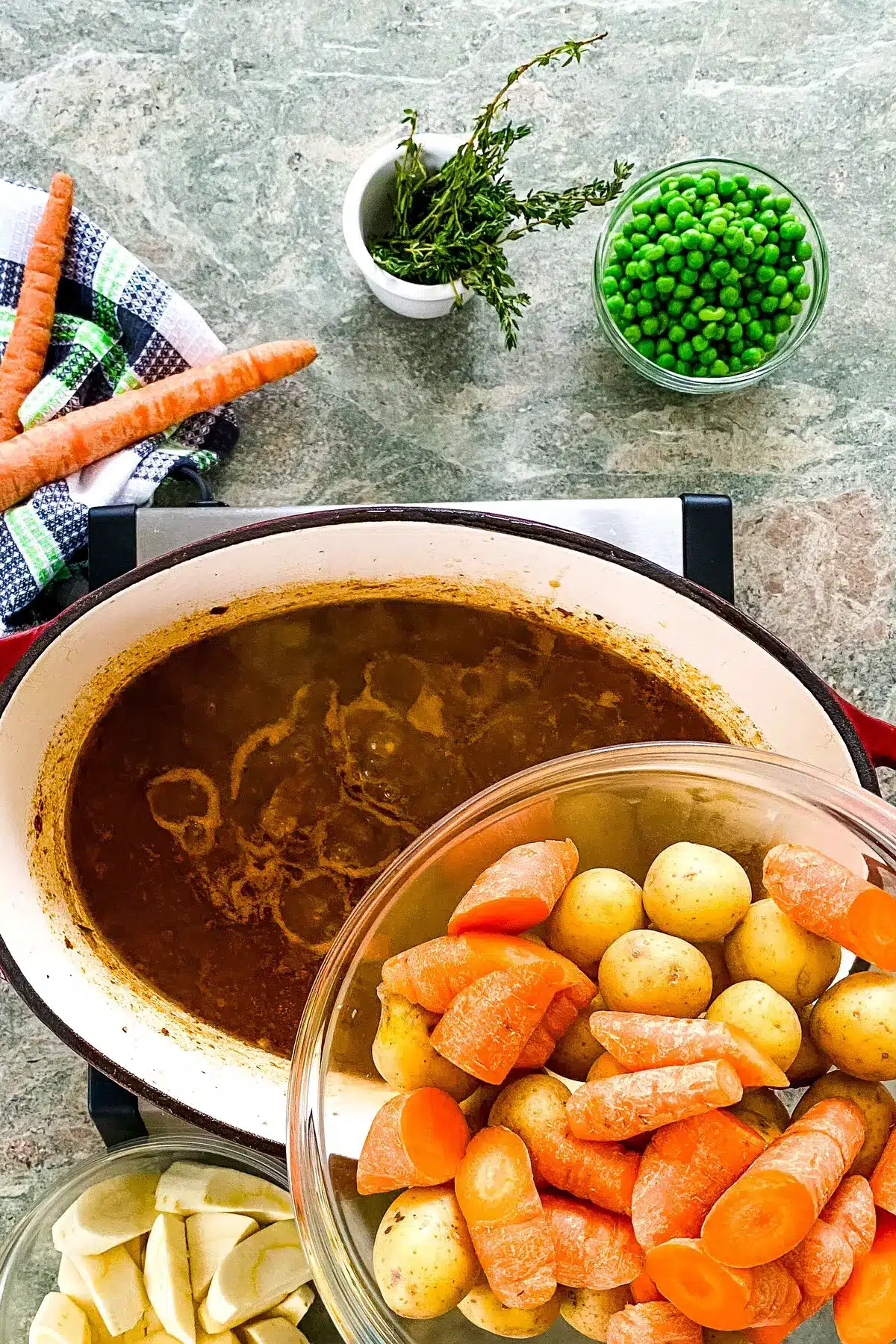 adding carrots, parsnips and peas to hearty Irish stew.