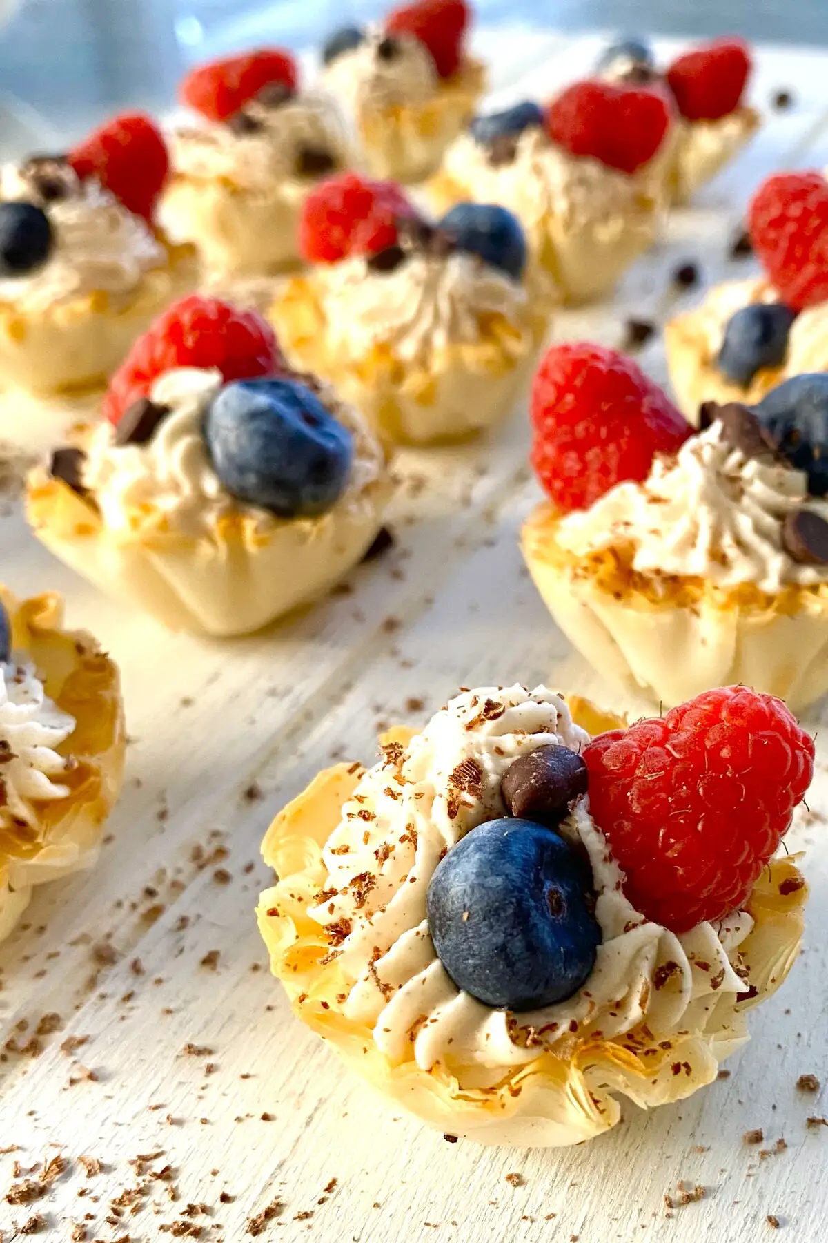 Mini Philadelphia no bake cheesecake recipe served in phyllo cups and topped with berries.